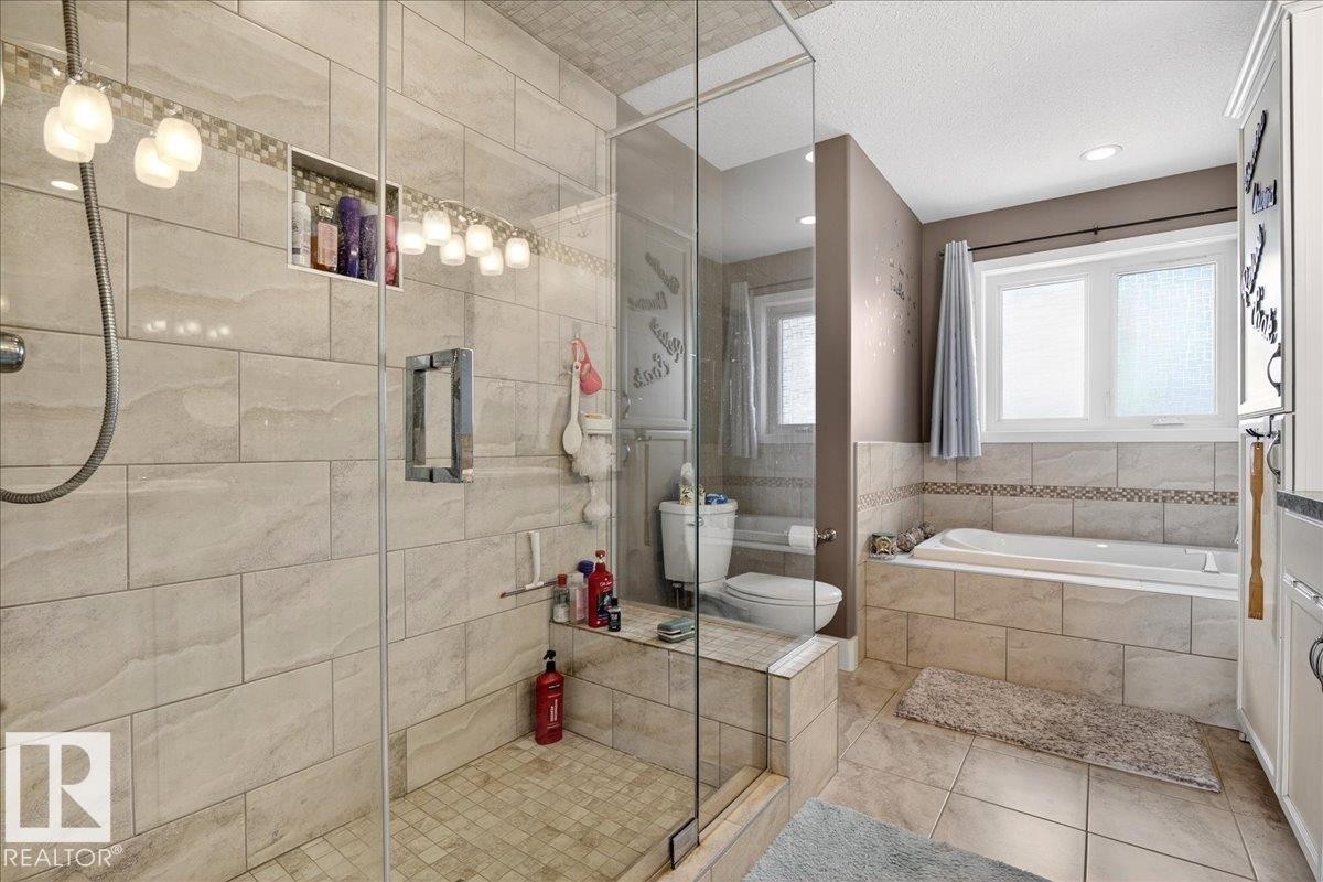 The interior features wood-paneled walls and ceilings, complemented by dark wood flooring and a staircase with a white balustrade - 531064 Range Road 174, Rural Lamont County, AB - Indoor Photo Showing Other Room