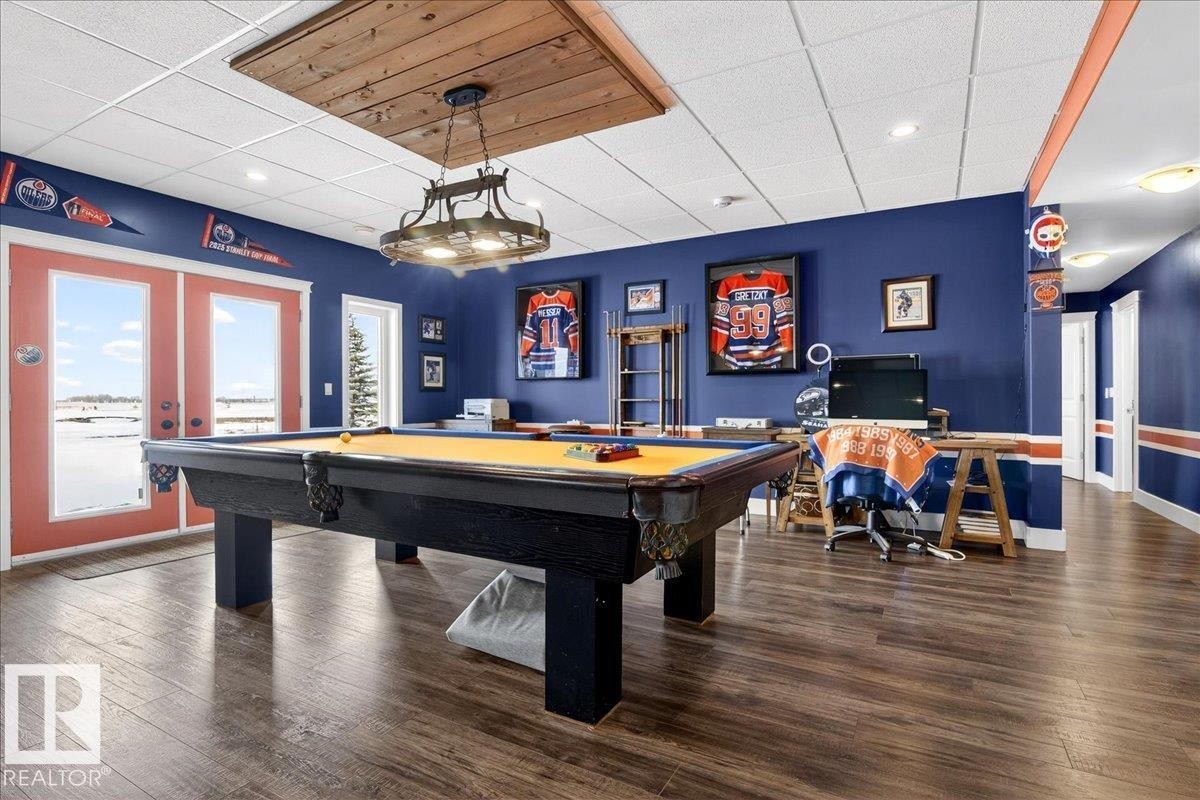 This spacious room features a stone fireplace, large windows, and recessed lighting - 531064 Range Road 174, Rural Lamont County, AB - Indoor With Fireplace