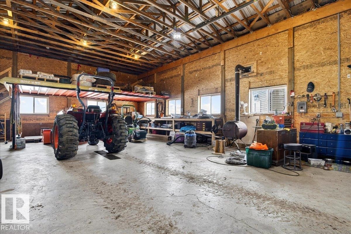 The property features an expansive outdoor deck with composite decking and a glass railing system, offering clear views of the surrounding landscape - 531064 Range Road 174, Rural Lamont County, AB - Outdoor With Deck Patio Veranda With Exterior