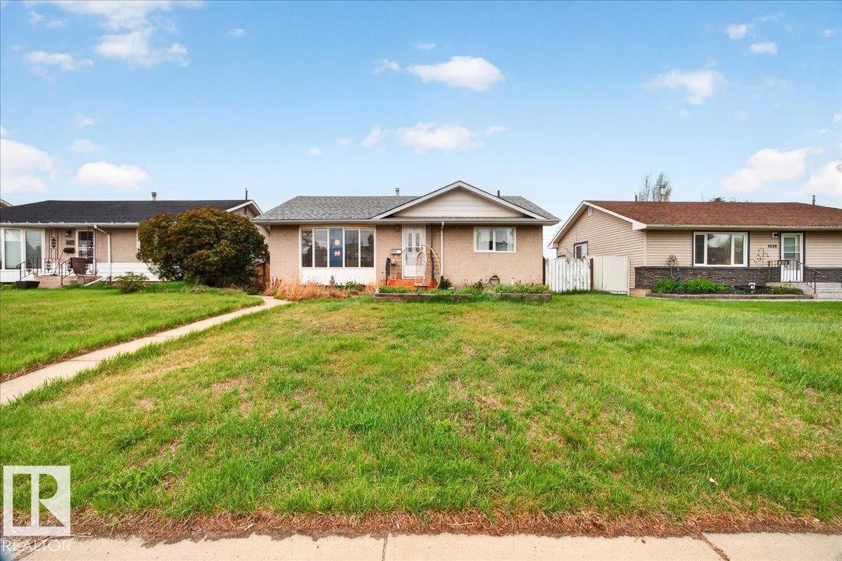 Ranch-style residence featuring a prominent bay window, light brick facade, and a grey asphalt shingle roof - 4212 105 Avenue, Edmonton, AB - Outdoor With Facade