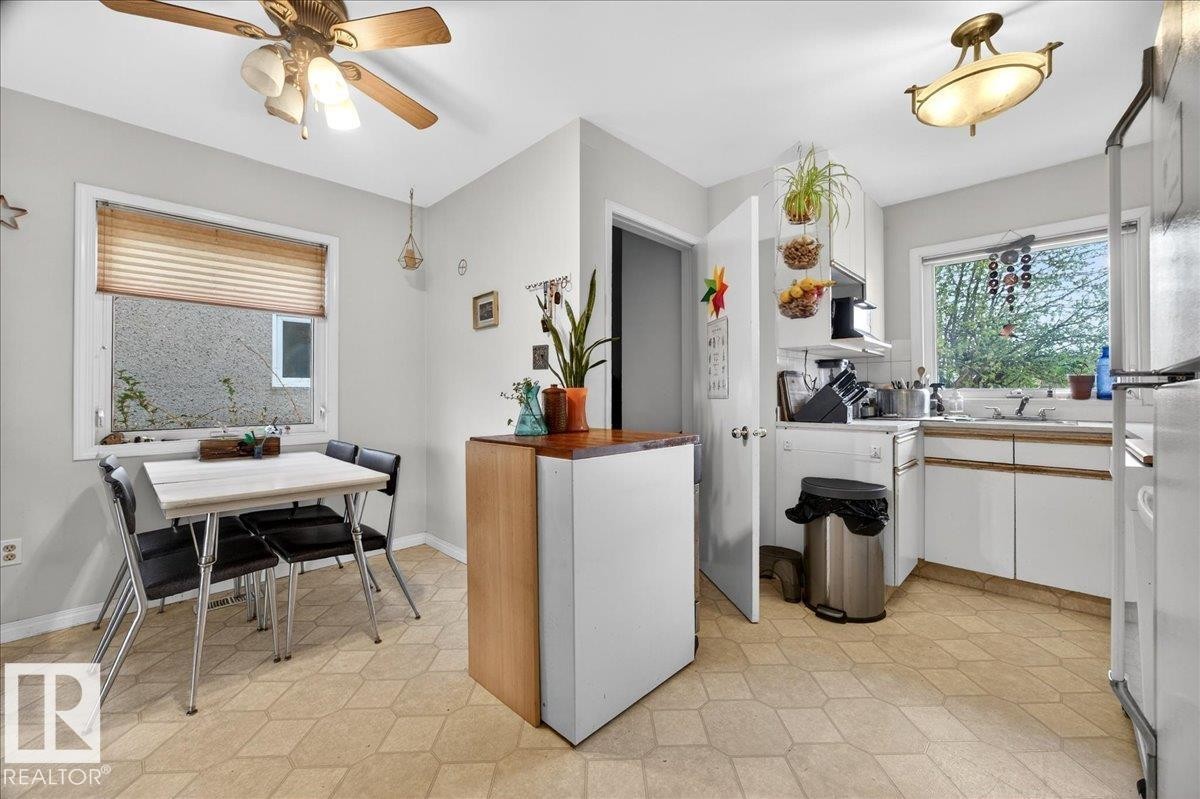 Kitchen featuring white cabinetry, a built-in sink, and light-toned geometric pattern flooring - 4212 105 Avenue, Edmonton, AB - Indoor