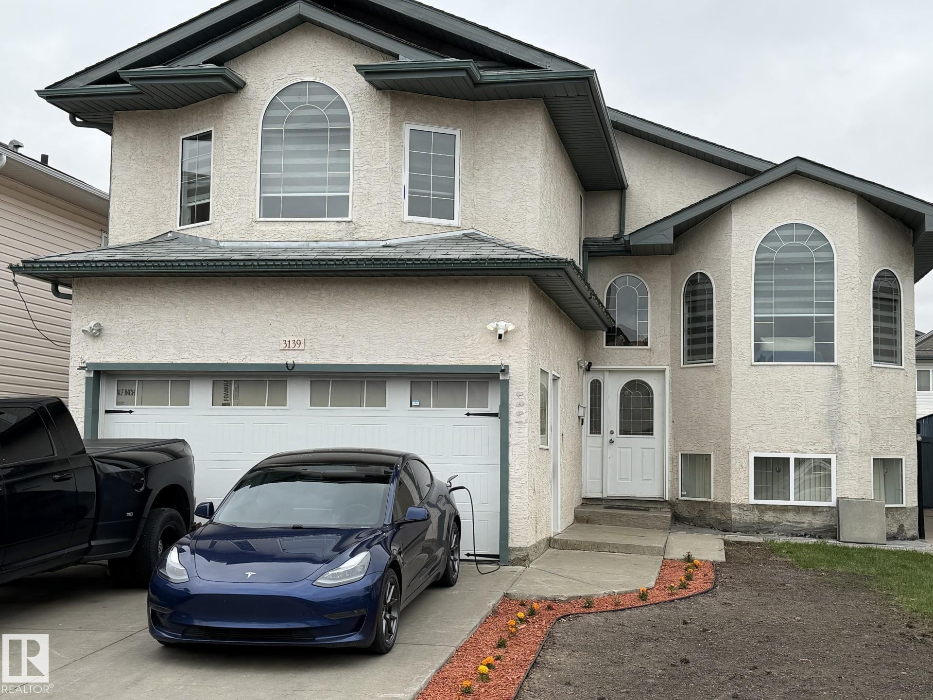 Stucco exterior featuring multiple arched windows and a prominent entry - 3139 34B Avenue, Edmonton, AB - Outdoor