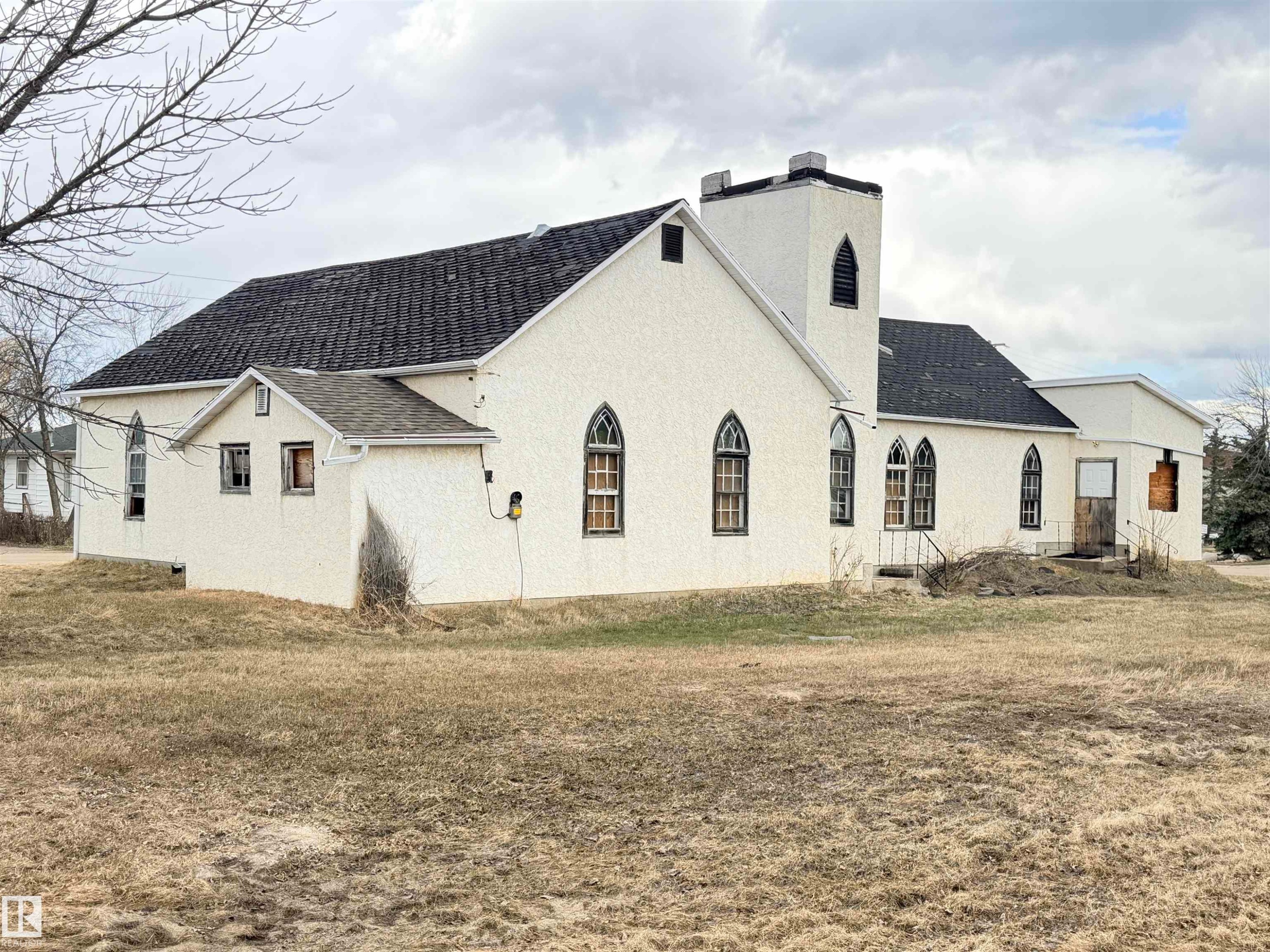 Stucco exterior with a dark shingle roof - 5036 49 Street, Clyde, AB - Outdoor