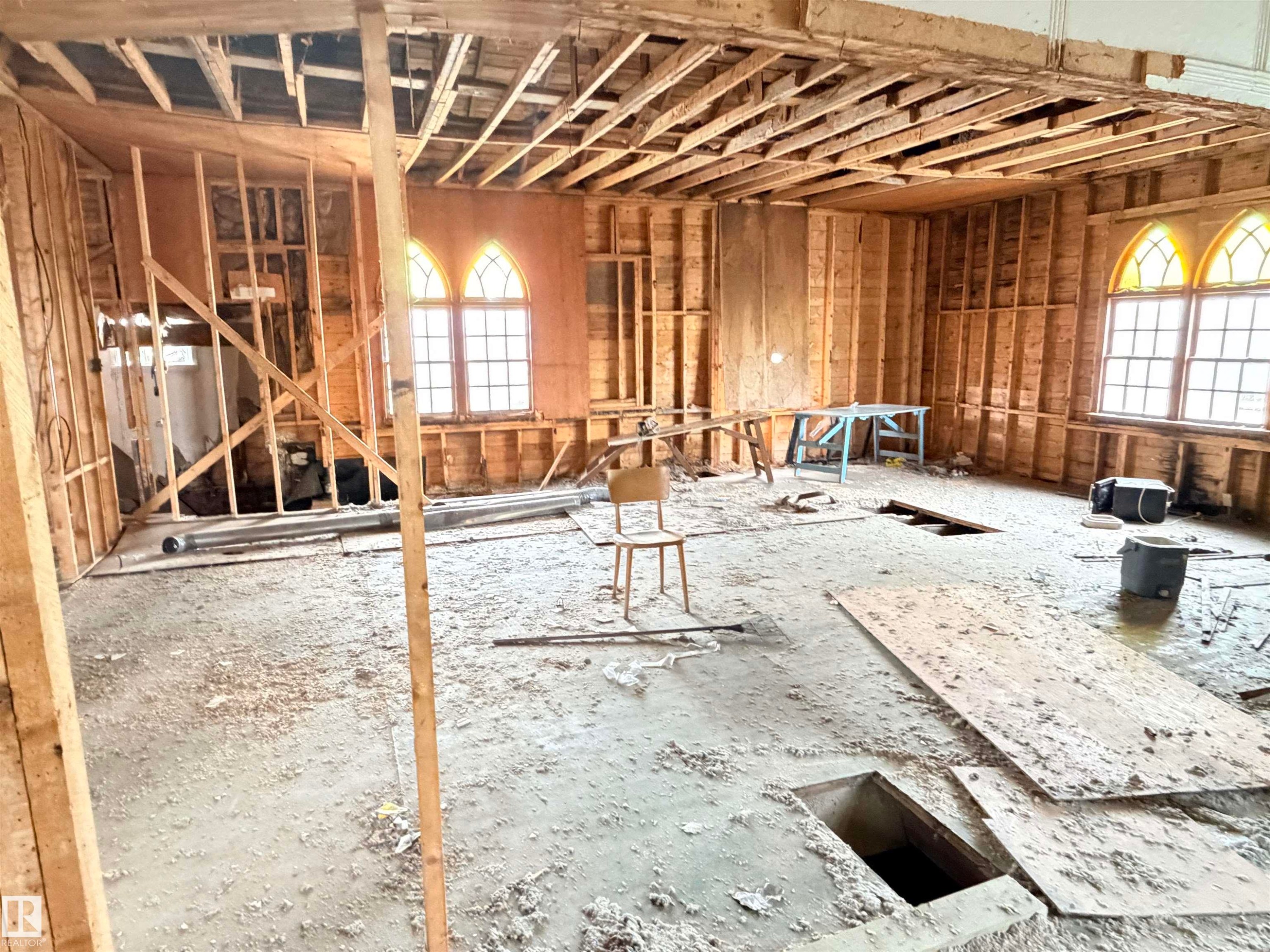 Interior space undergoing renovation, featuring exposed wood wall studs and ceiling joists - 5036 49 Street, Clyde, AB - Indoor