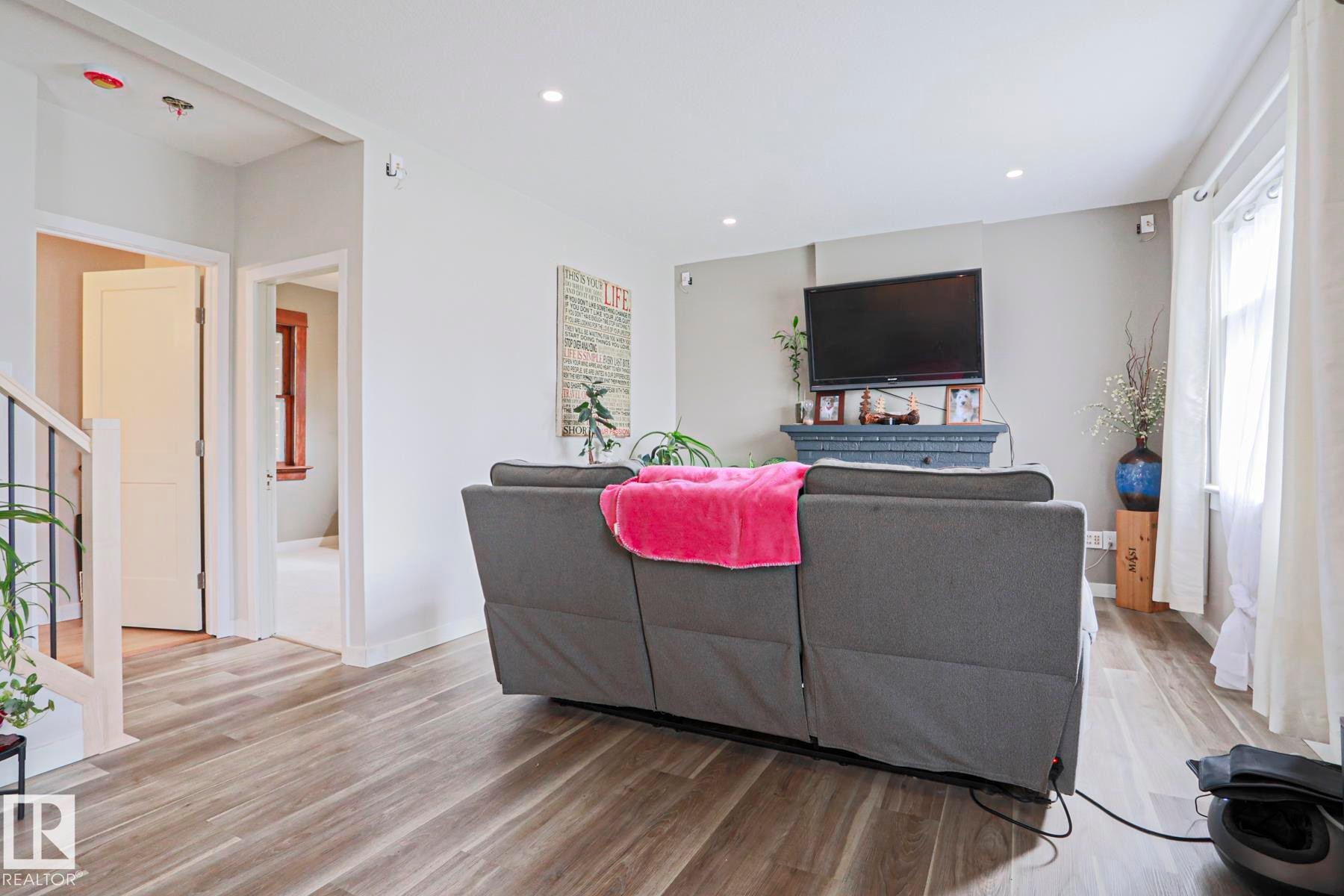 Living area featuring wood-finish flooring, recessed lighting, and a neutral color palette - 5113 53 Avenue, Stony Plain, AB - Indoor