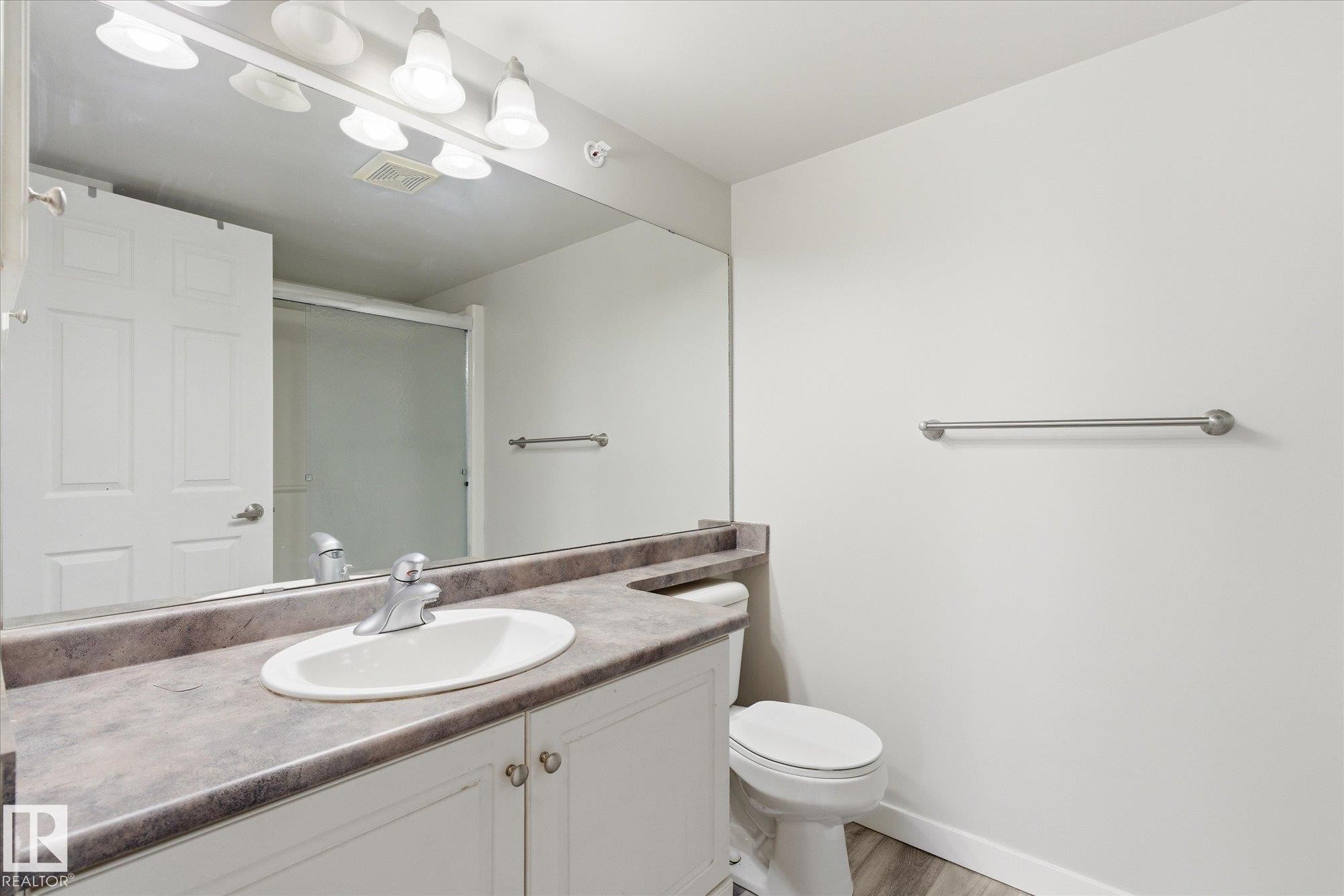 Bathroom vanity with a white oval sink and a gray-patterned countertop - 407 13635 34 Street Nw, Edmonton, AB - Indoor Photo Showing Bathroom