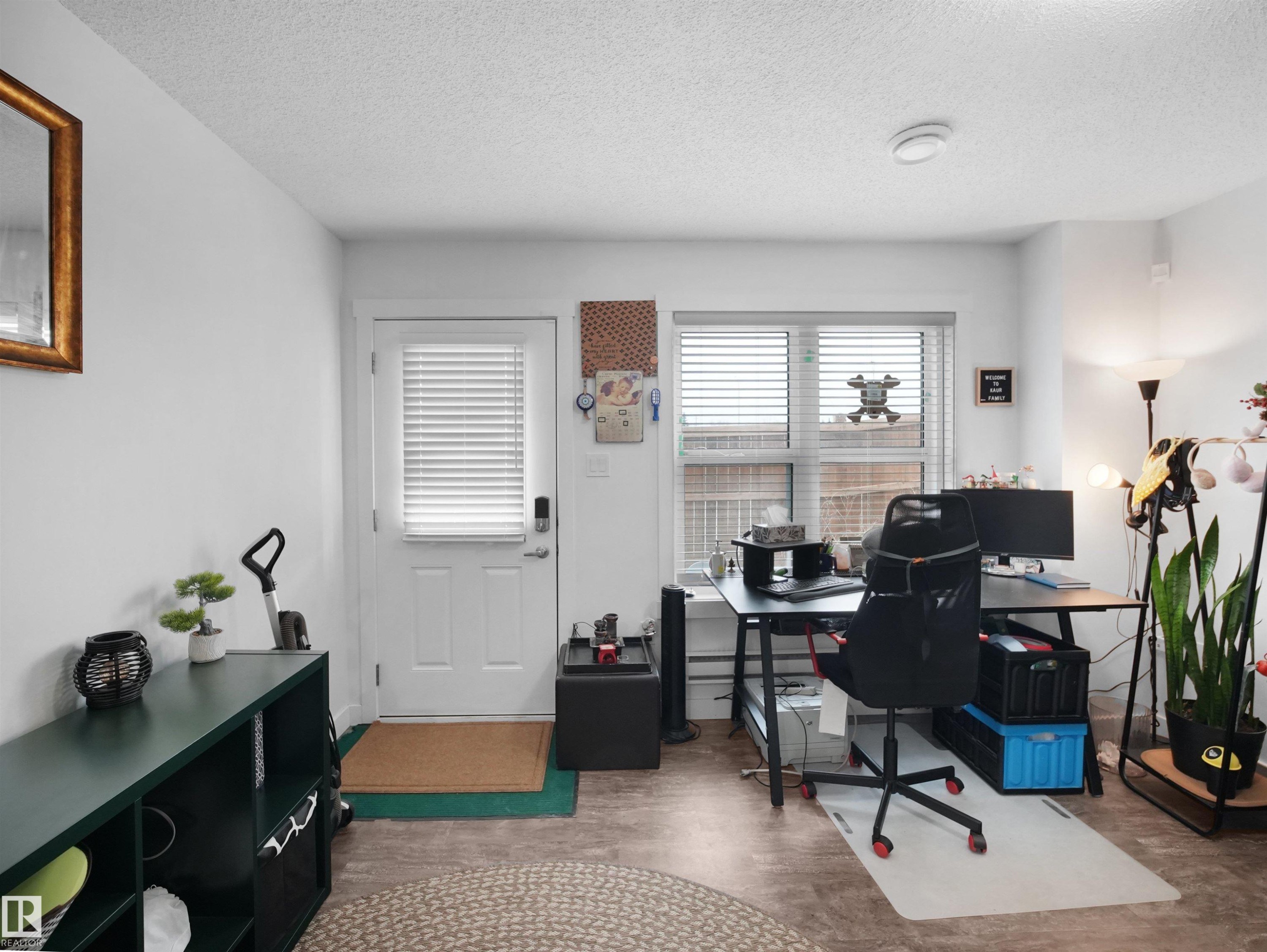 This versatile room features light-colored walls, a window with horizontal blinds, and a white door with a keyless entry system - 64 655 Watt Boulevard, Edmonton, AB - Indoor Photo Showing Office