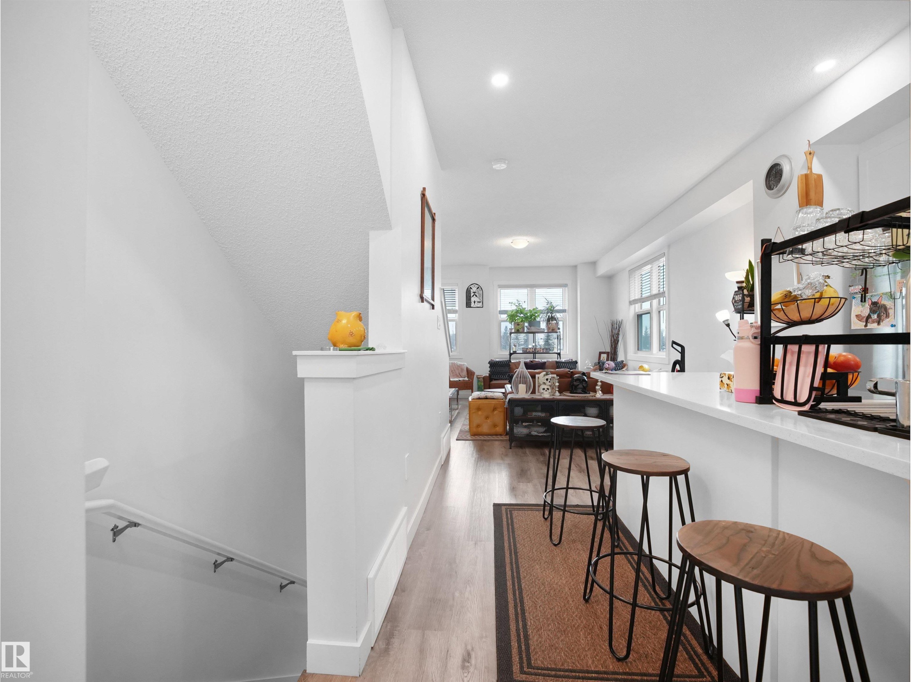 The property features an open-concept layout with light-toned flooring and white walls, creating a bright and airy atmosphere - 64 655 Watt Boulevard, Edmonton, AB - Indoor Photo Showing Other Room