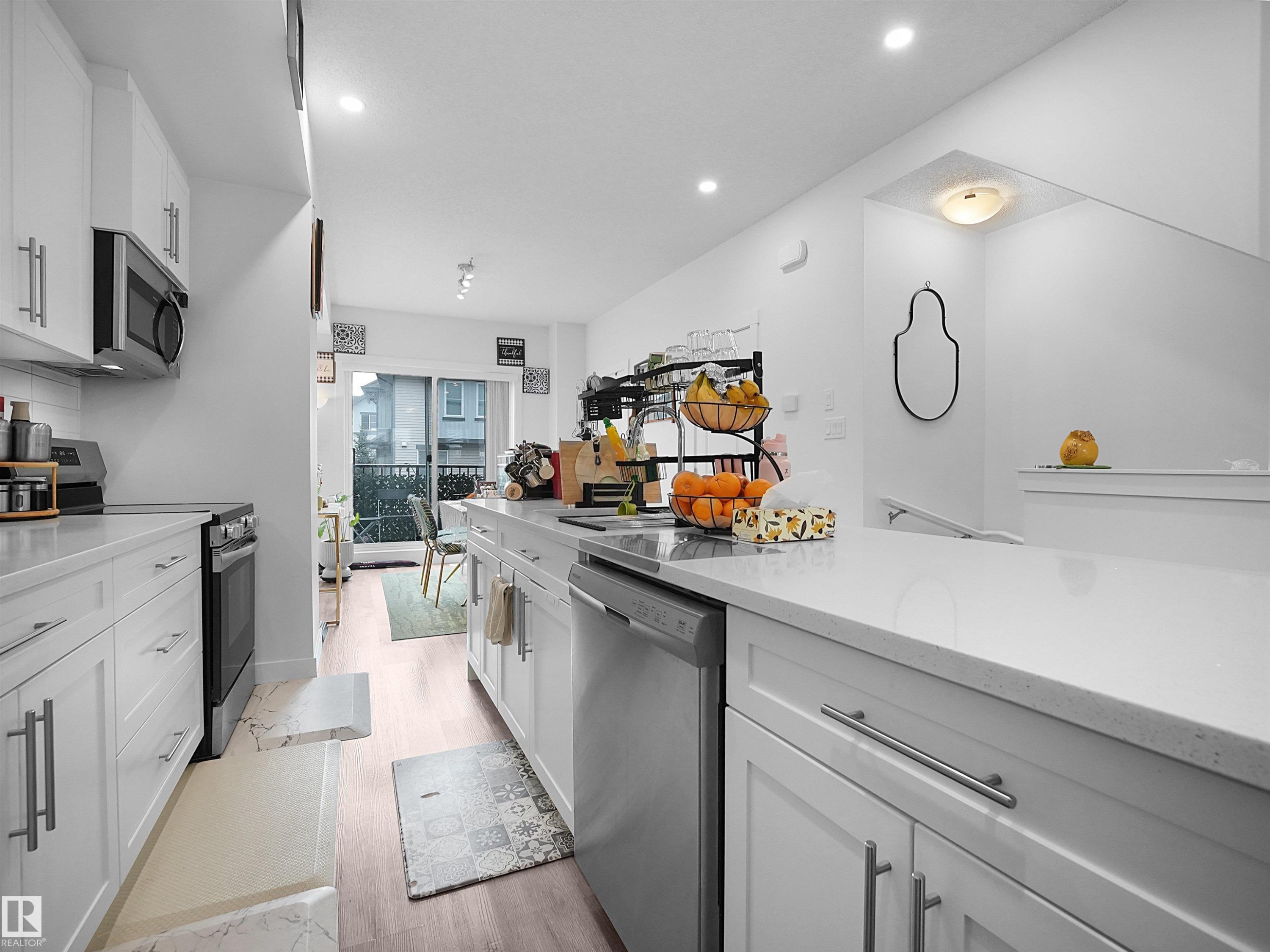 Kitchen featuring white cabinetry, stainless steel appliances, and light-colored countertops - 64 655 Watt Boulevard, Edmonton, AB - Indoor Photo Showing Kitchen With Upgraded Kitchen
