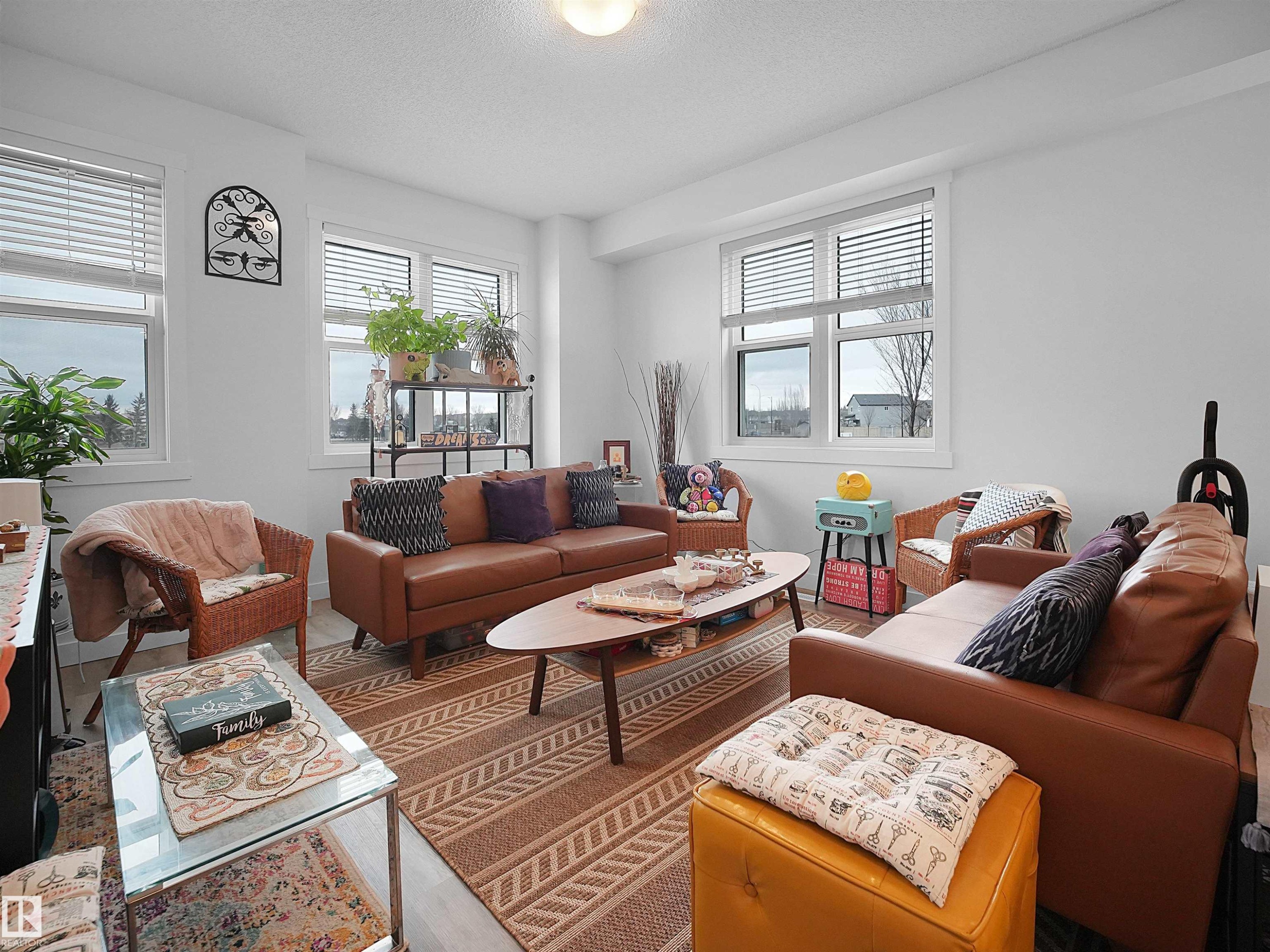 The living area features light-colored walls and flooring, with several windows providing natural light - 64 655 Watt Boulevard, Edmonton, AB - Indoor Photo Showing Living Room