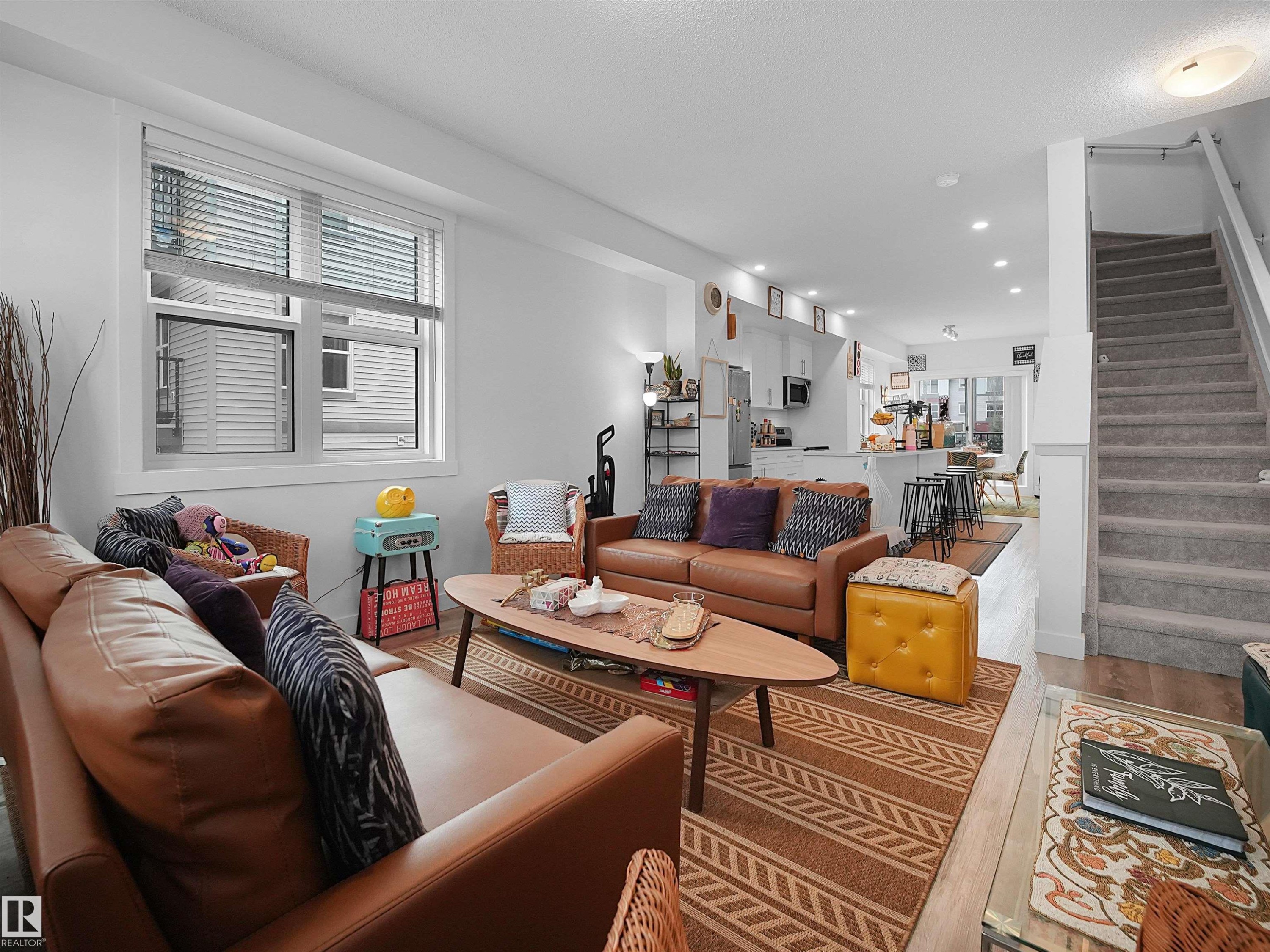 The open concept living area features light-colored walls and a window with blinds, providing natural light - 64 655 Watt Boulevard, Edmonton, AB - Indoor Photo Showing Living Room