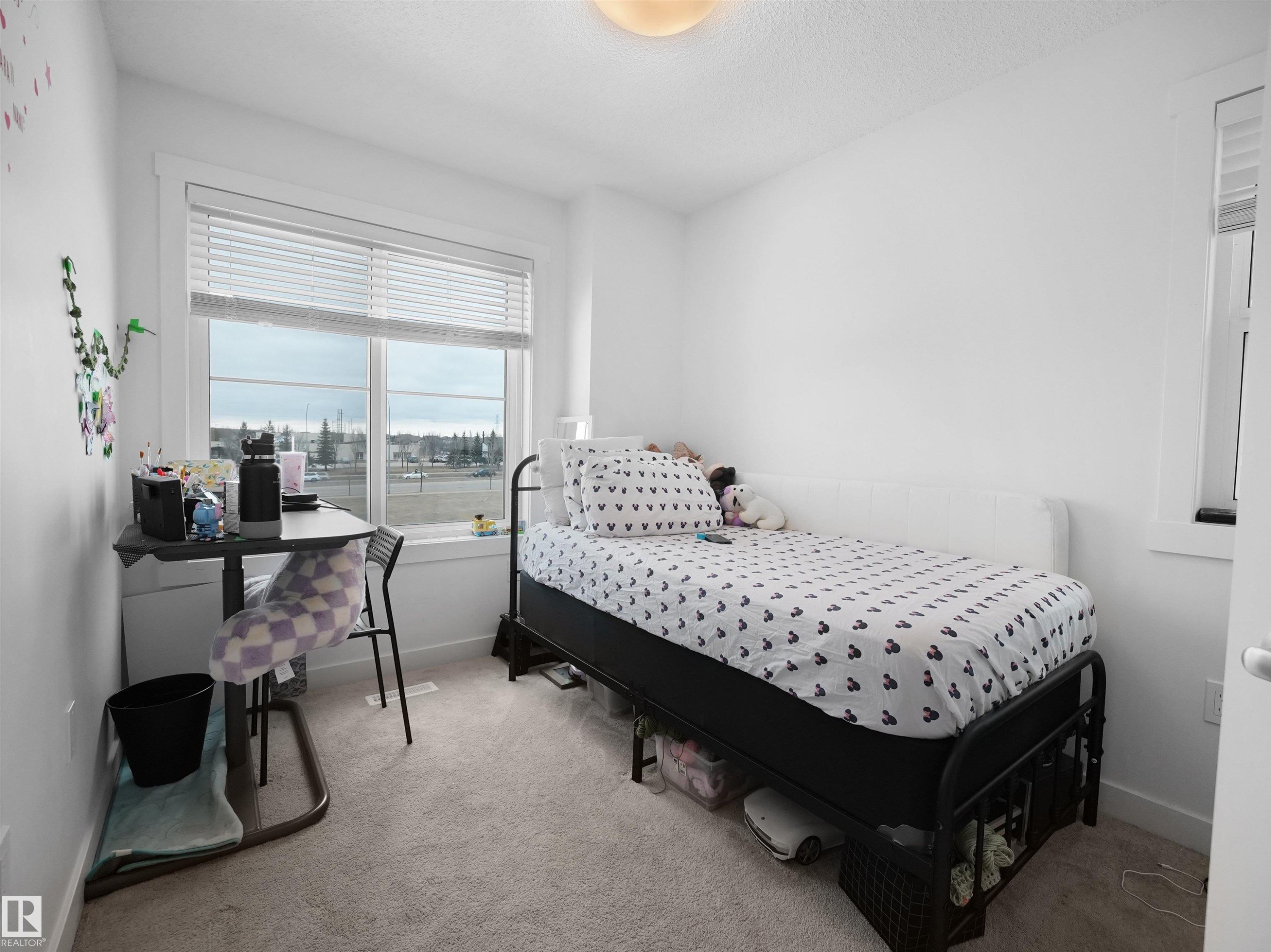 This room features a large window with blinds, light-colored carpet, and white painted walls - 64 655 Watt Boulevard, Edmonton, AB - Indoor Photo Showing Bedroom