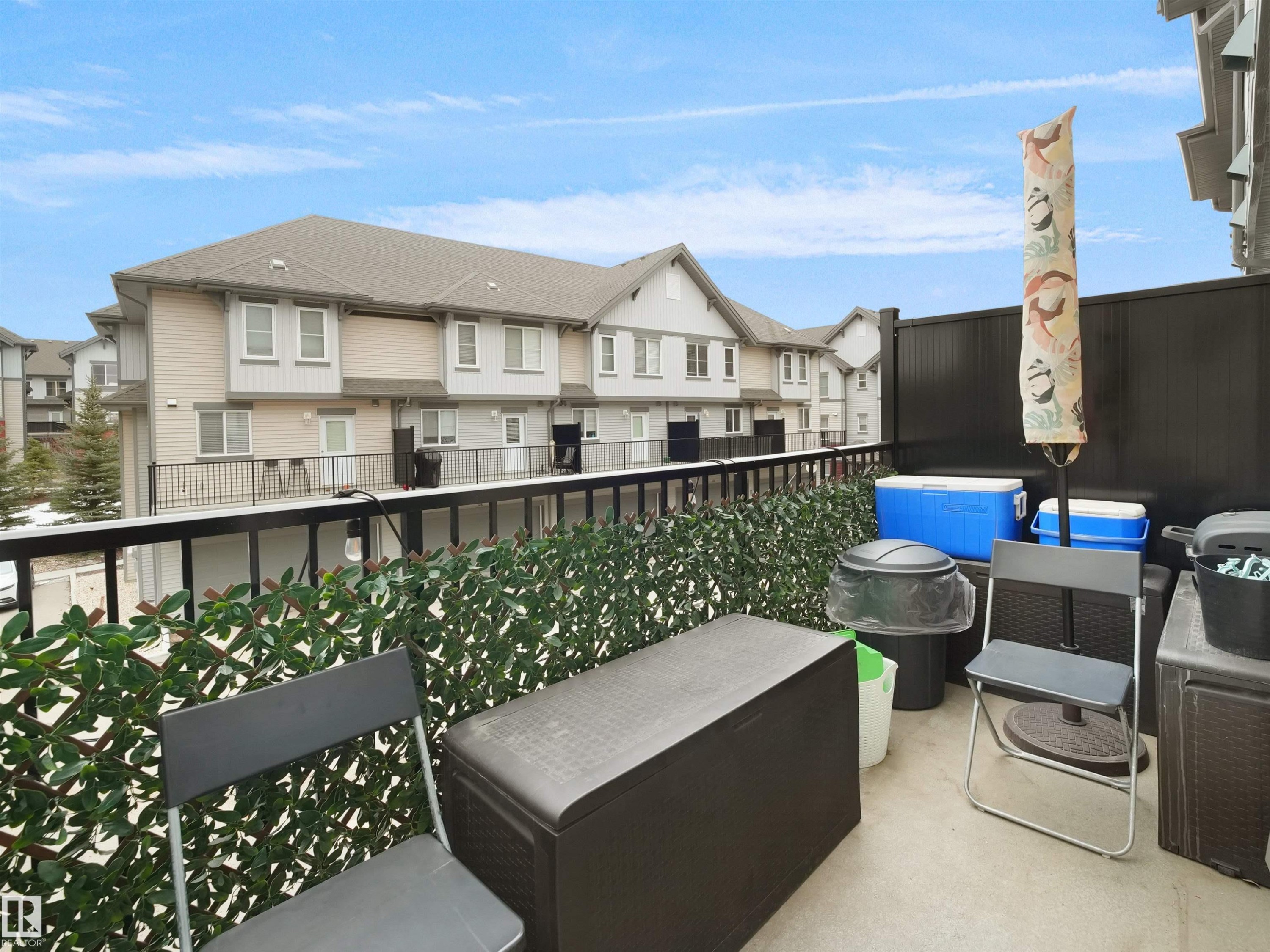 The property features a concrete balcony with a black metal railing and a privacy screen - 64 655 Watt Boulevard, Edmonton, AB - Outdoor With Exterior