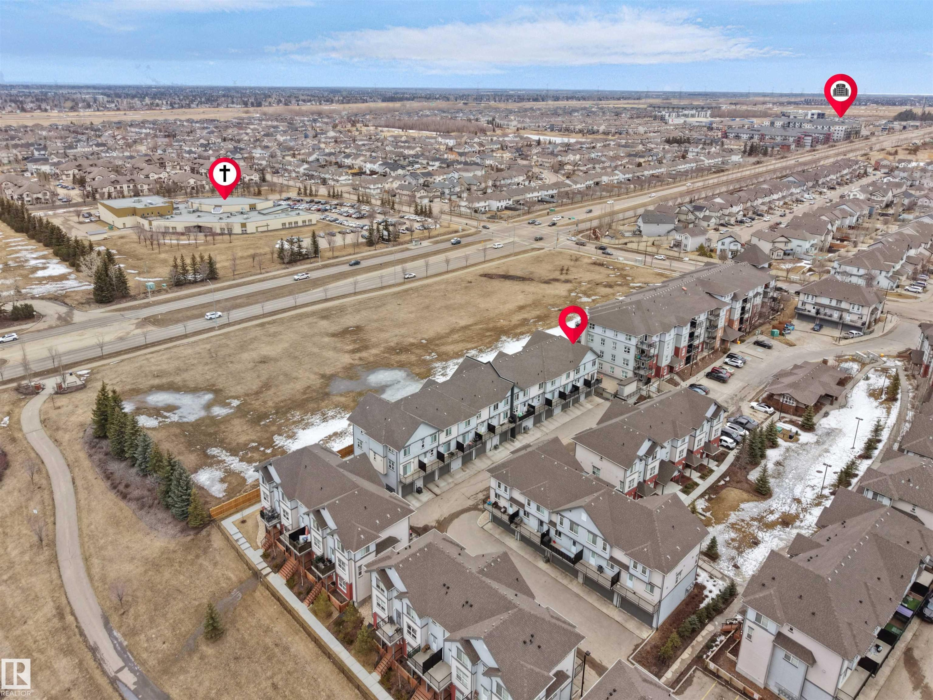 Aerial view showcasing the property's location within a developed community, featuring residential buildings and nearby infrastructure - 64 655 Watt Boulevard, Edmonton, AB - Outdoor With View