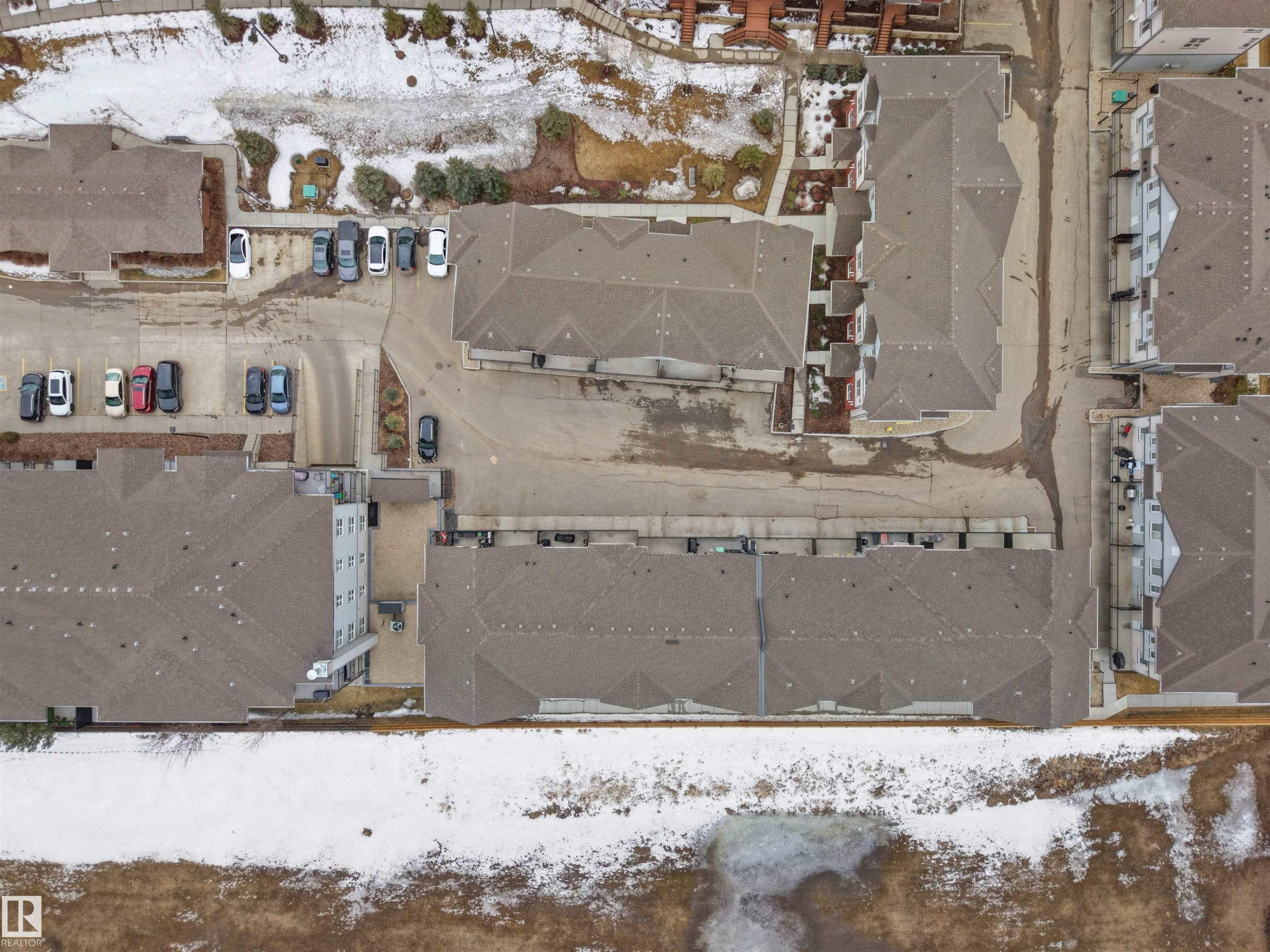 Aerial view of the property and its surrounding area, featuring various buildings with sloped roofs and parking areas - 64 655 Watt Boulevard, Edmonton, AB - Outdoor With View