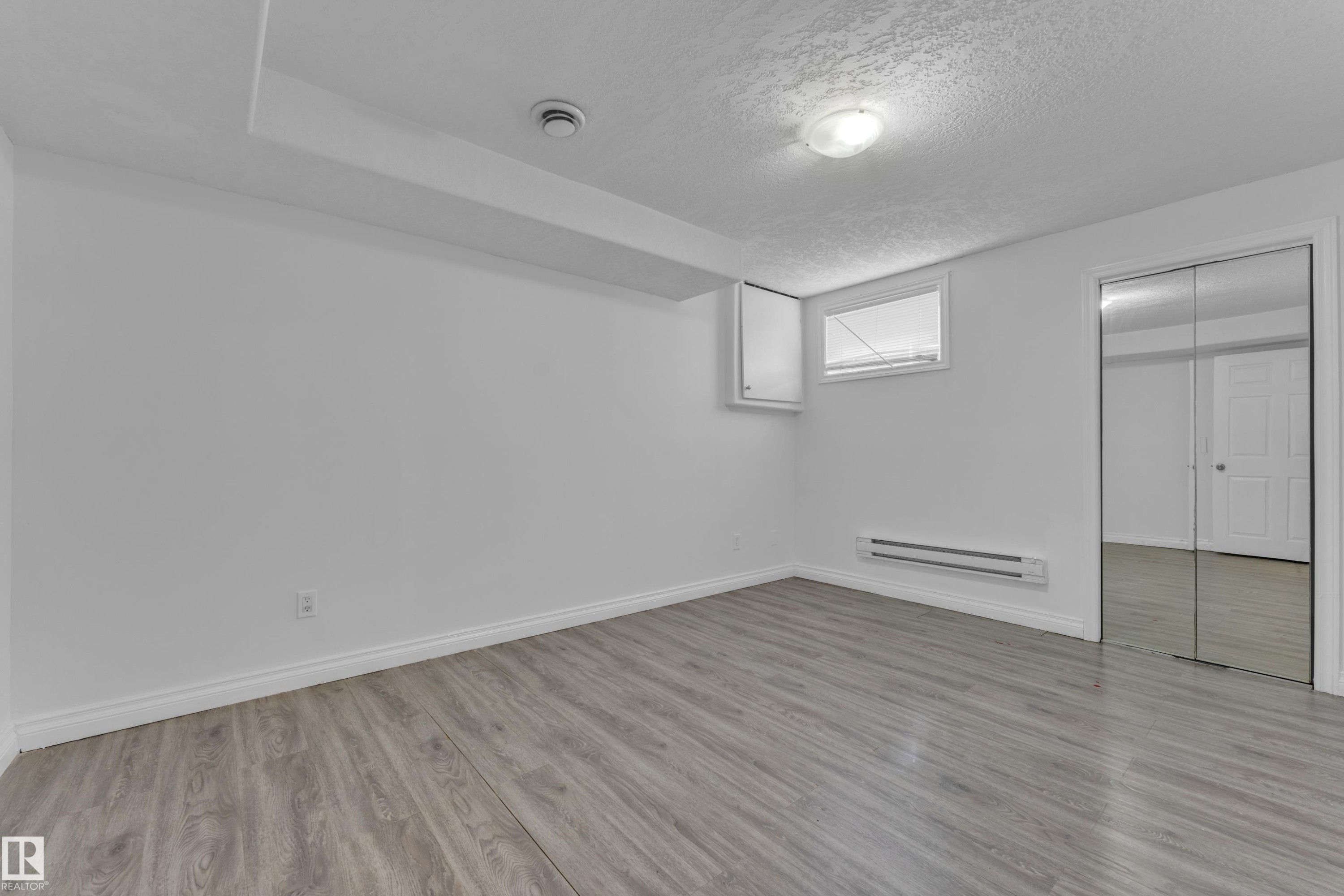 Room featuring wood-finish flooring, white baseboards, and a white ceiling - 3520 19 Avenue, Edmonton, AB