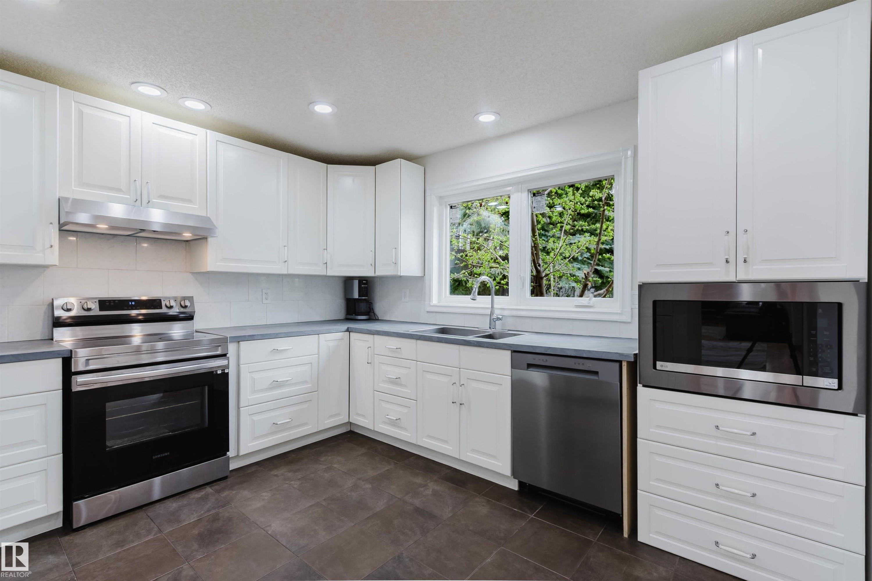 Kitchen featuring white cabinetry, stainless steel appliances, grey countertops, a white subway tile backsplash, and recessed lighting - 342 O'Connor Close, Edmonton, AB - Indoor Photo Showing Kitchen With Double Sink