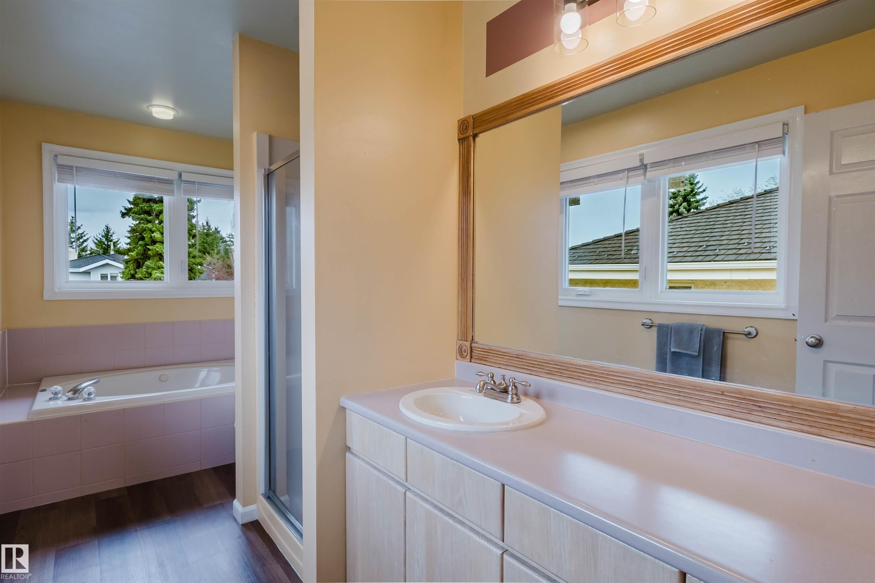 Bathroom vanity with an integrated sink, expansive mirror, and overhead lighting - 342 O'Connor Close, Edmonton, AB - Indoor Photo Showing Bathroom