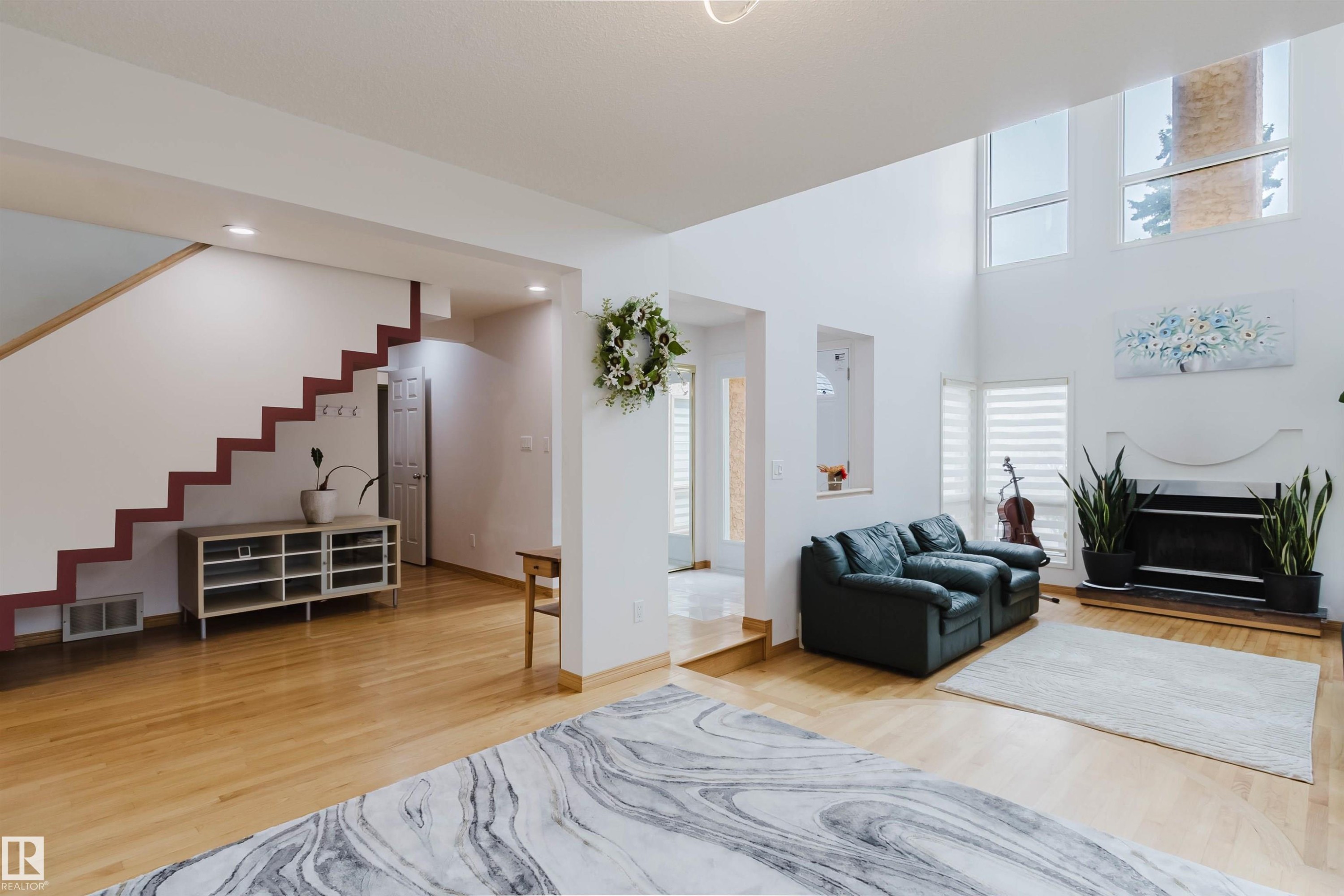 Spacious living area featuring high ceilings, large windows, and light wood-finish flooring - 342 O'Connor Close, Edmonton, AB - Indoor Photo Showing Living Room With Fireplace