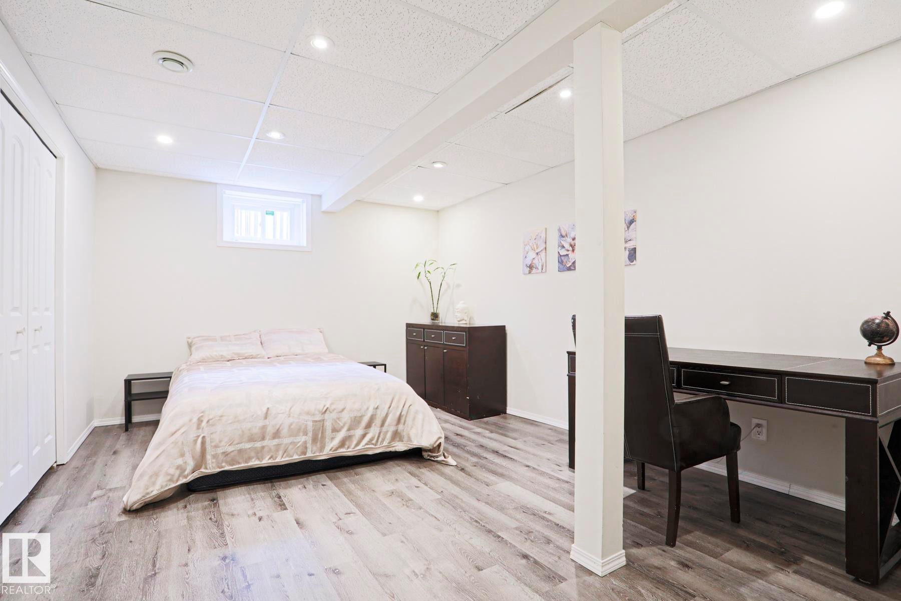 Finished interior space featuring wood-finish flooring, recessed lighting, and a white drop ceiling - 9523 151 Street, Edmonton, AB - Indoor Photo Showing Bedroom