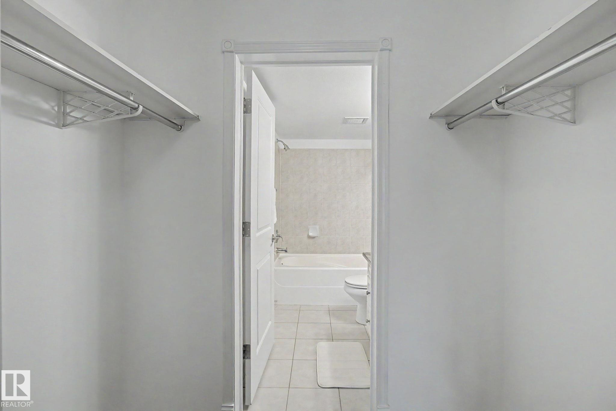 Walk-in closet featuring dual shelving and hanging rods - 213 17404 64 Avenue, Edmonton, AB