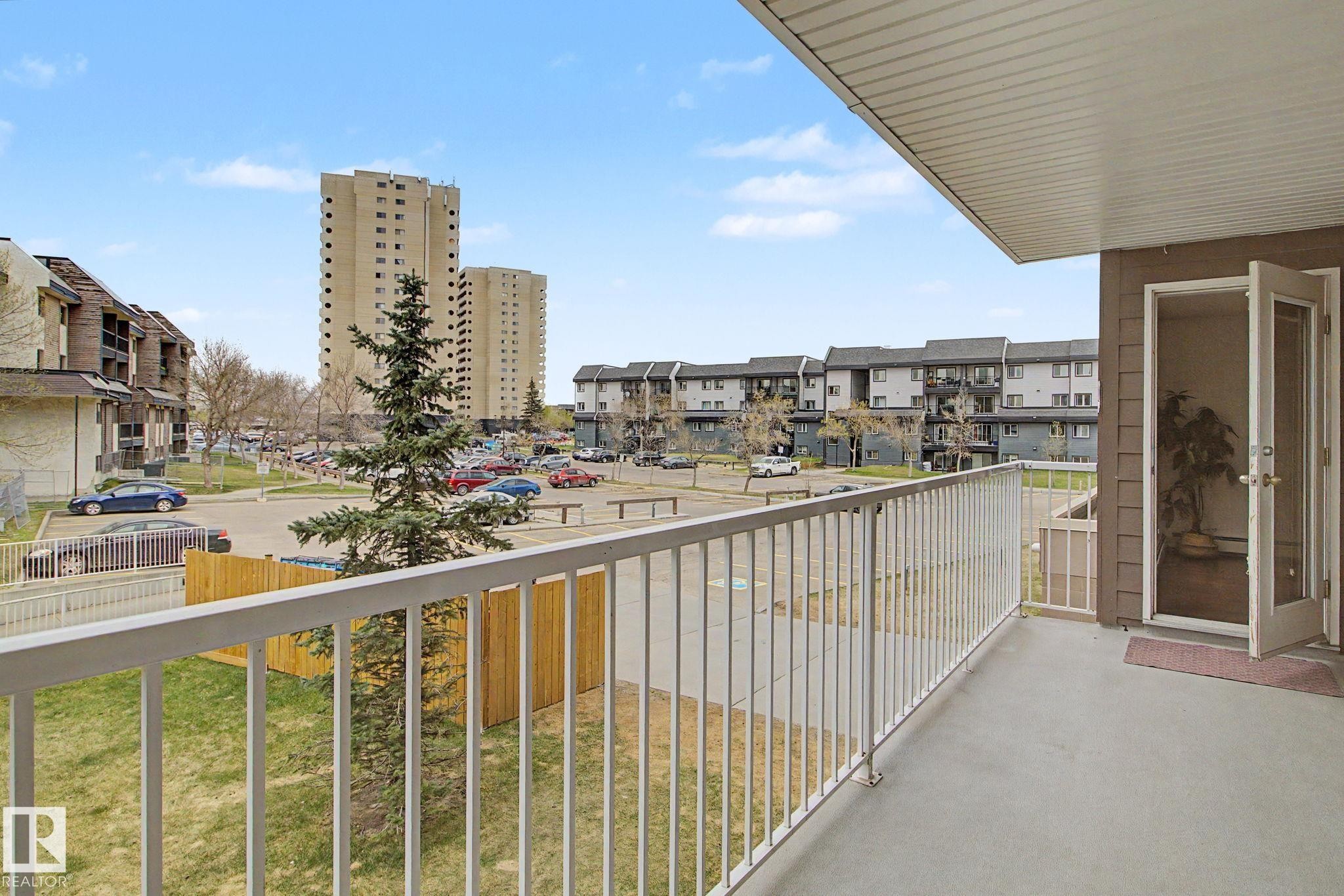 Private balcony with concrete flooring, white metal railing, and a glass-paneled door - 213 17404 64 Avenue, Edmonton, AB