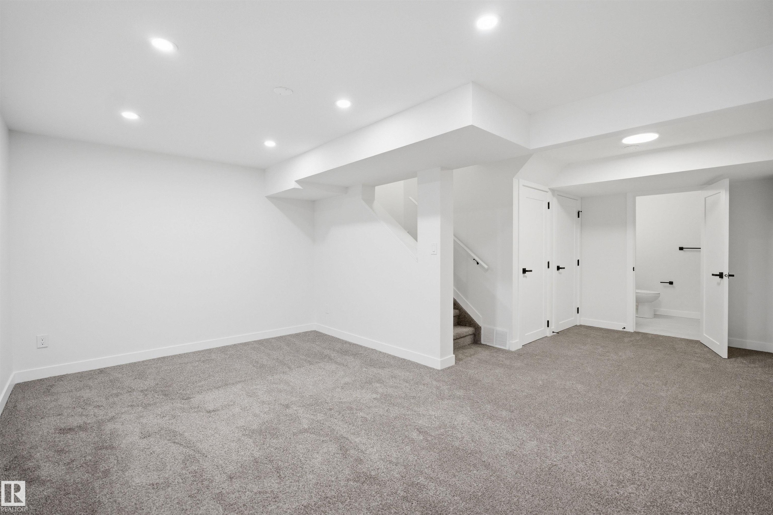Spacious lower-level room featuring light gray carpeting, white walls, and recessed lighting - 1706 37 Street, Edmonton, AB - Indoor
