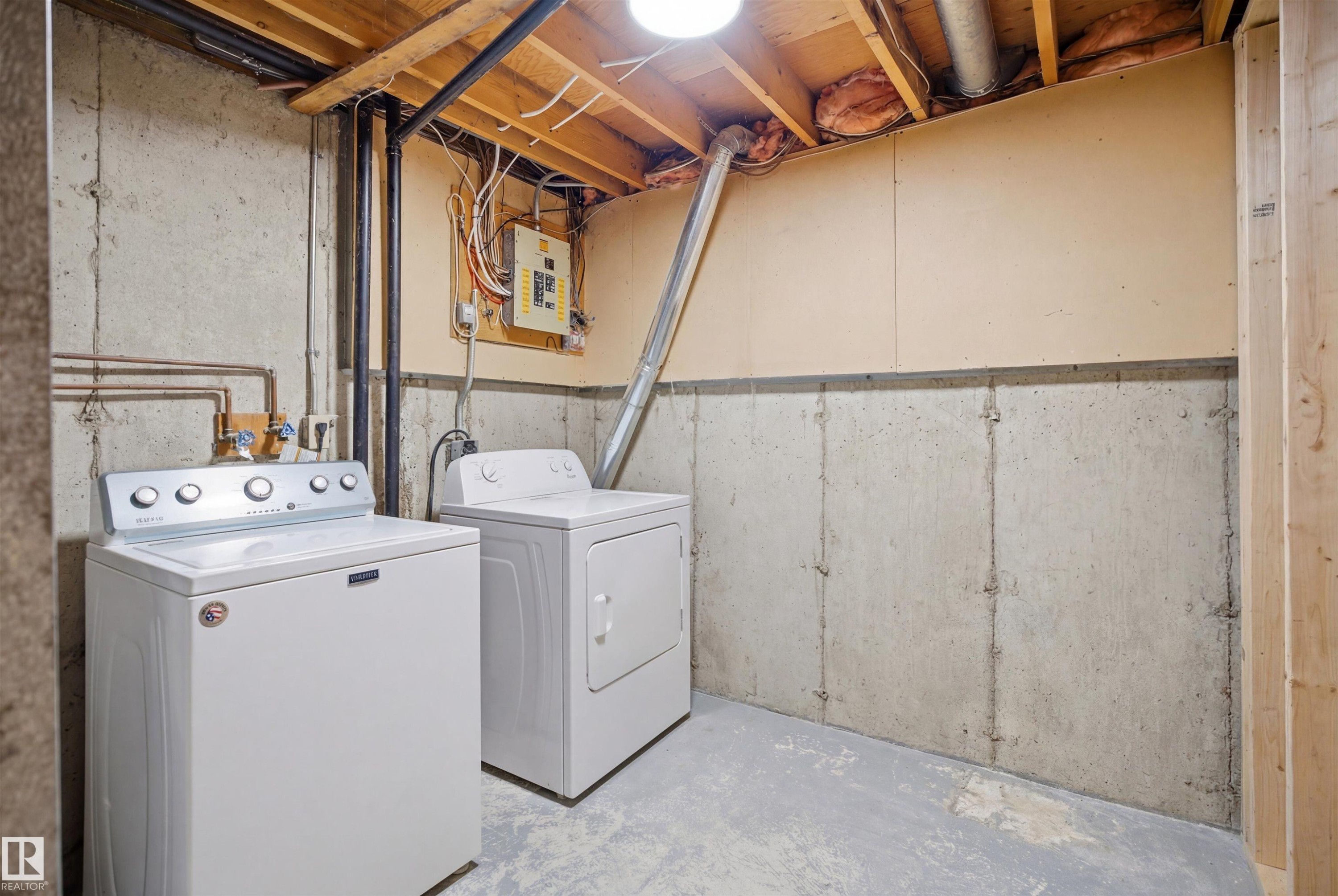 Utility space featuring concrete slab flooring, concrete foundation walls, and an exposed wood beam ceiling - 1706 37 Street, Edmonton, AB - Indoor Photo Showing Laundry Room