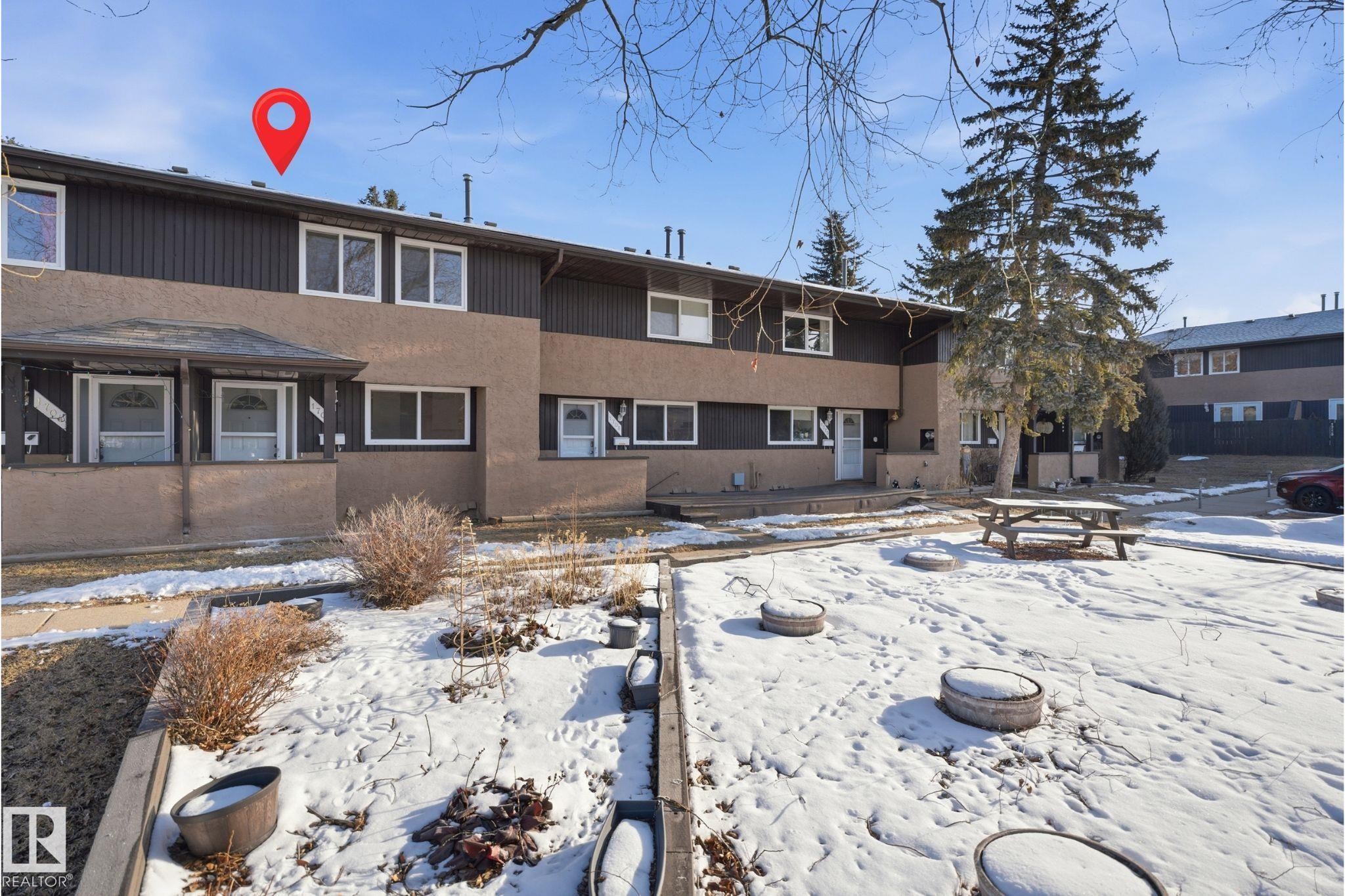 Townhome exterior featuring a combination of dark brown siding and light brown stucco, white trim windows, and individual entryways - 1706 37 Street, Edmonton, AB - Outdoor