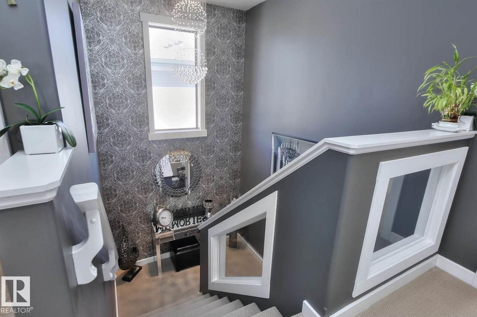 Stairwell featuring white trim and a window with crystal chandelier - 2016 125 Street, Edmonton, AB - Photo Showing Other Room