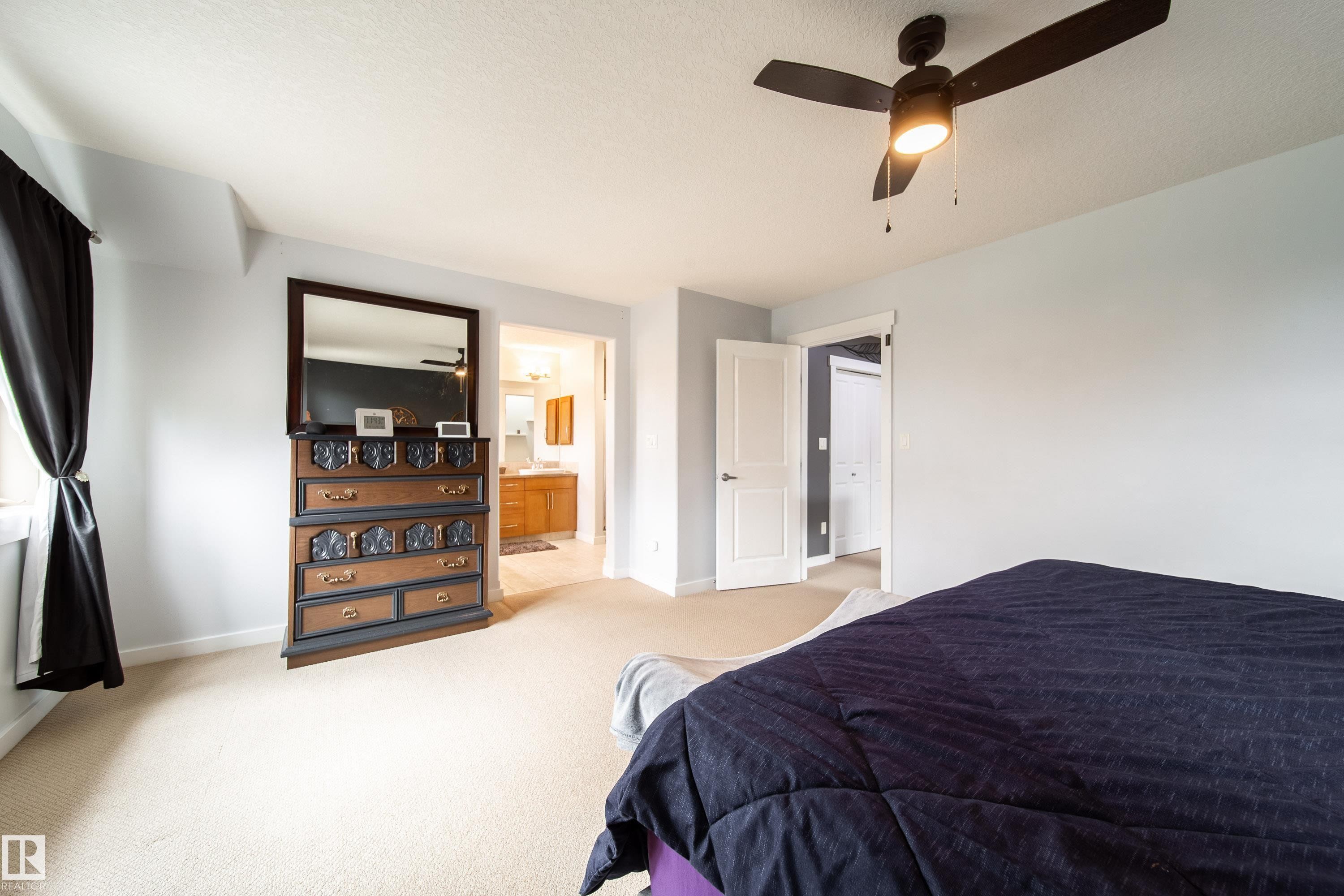 Carpeted bedroom with a ceiling fan light fixture and light blue painted walls - 2016 125 Street, Edmonton, AB - Indoor Photo Showing Bedroom