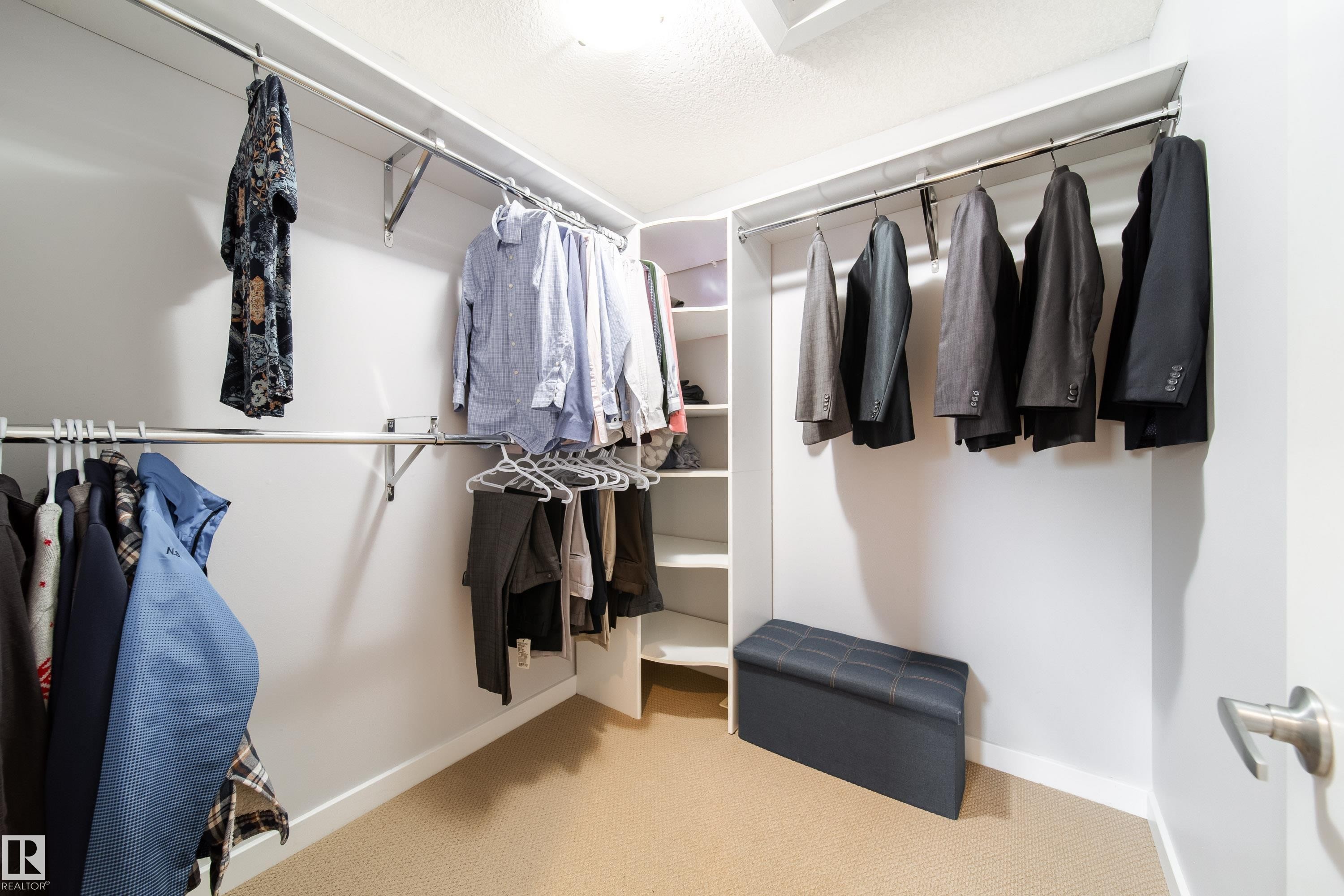 Walk-in closet featuring multiple hanging rods, built-in shelving, white walls, and light-colored carpeting - 2016 125 Street, Edmonton, AB - Indoor With Storage