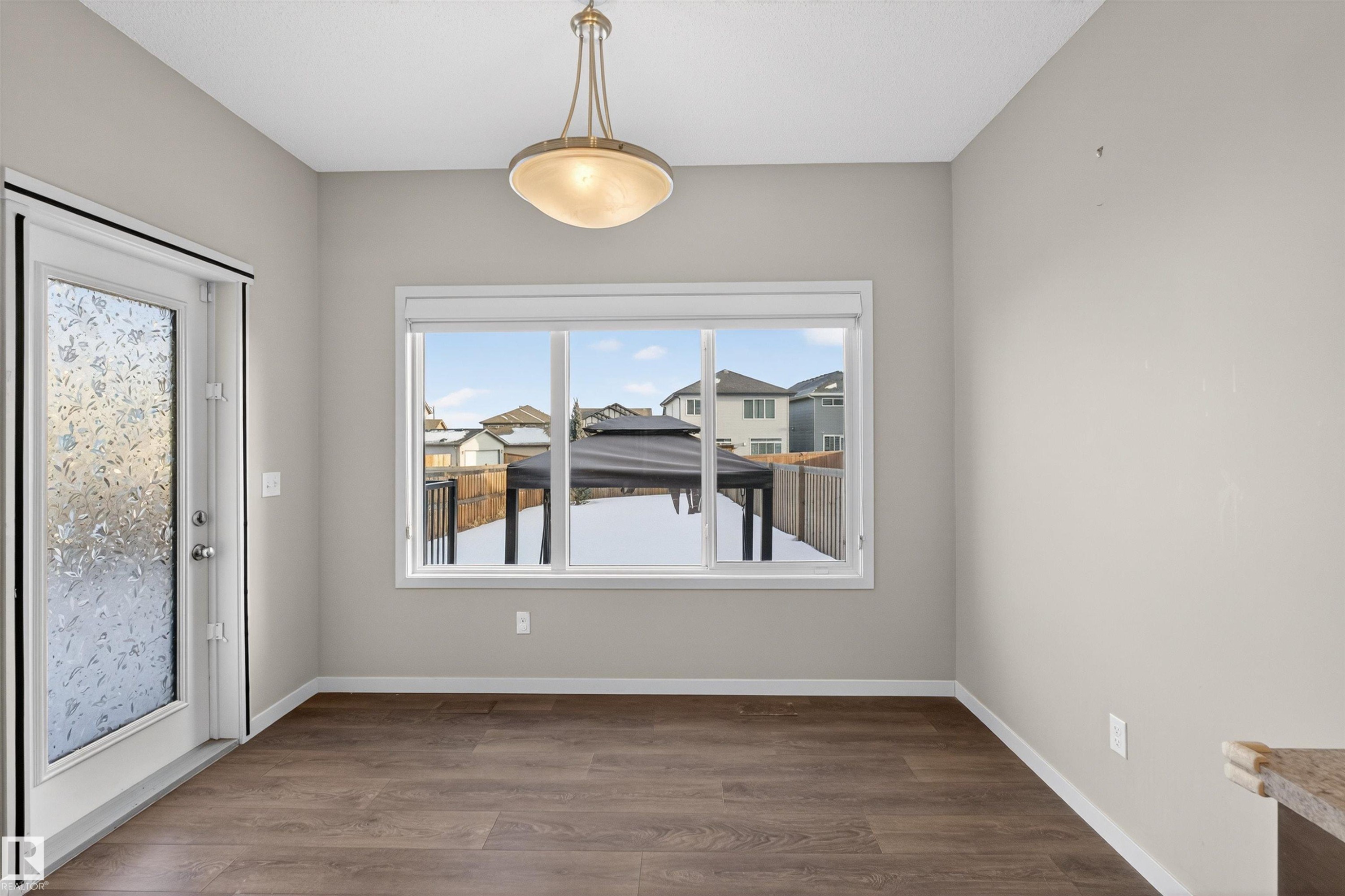 Contemporary interior with wood-finish flooring, neutral wall tones, and a rear-facing window - 4723 Alwood Bend Sw, Edmonton, AB - Indoor Photo Showing Other Room