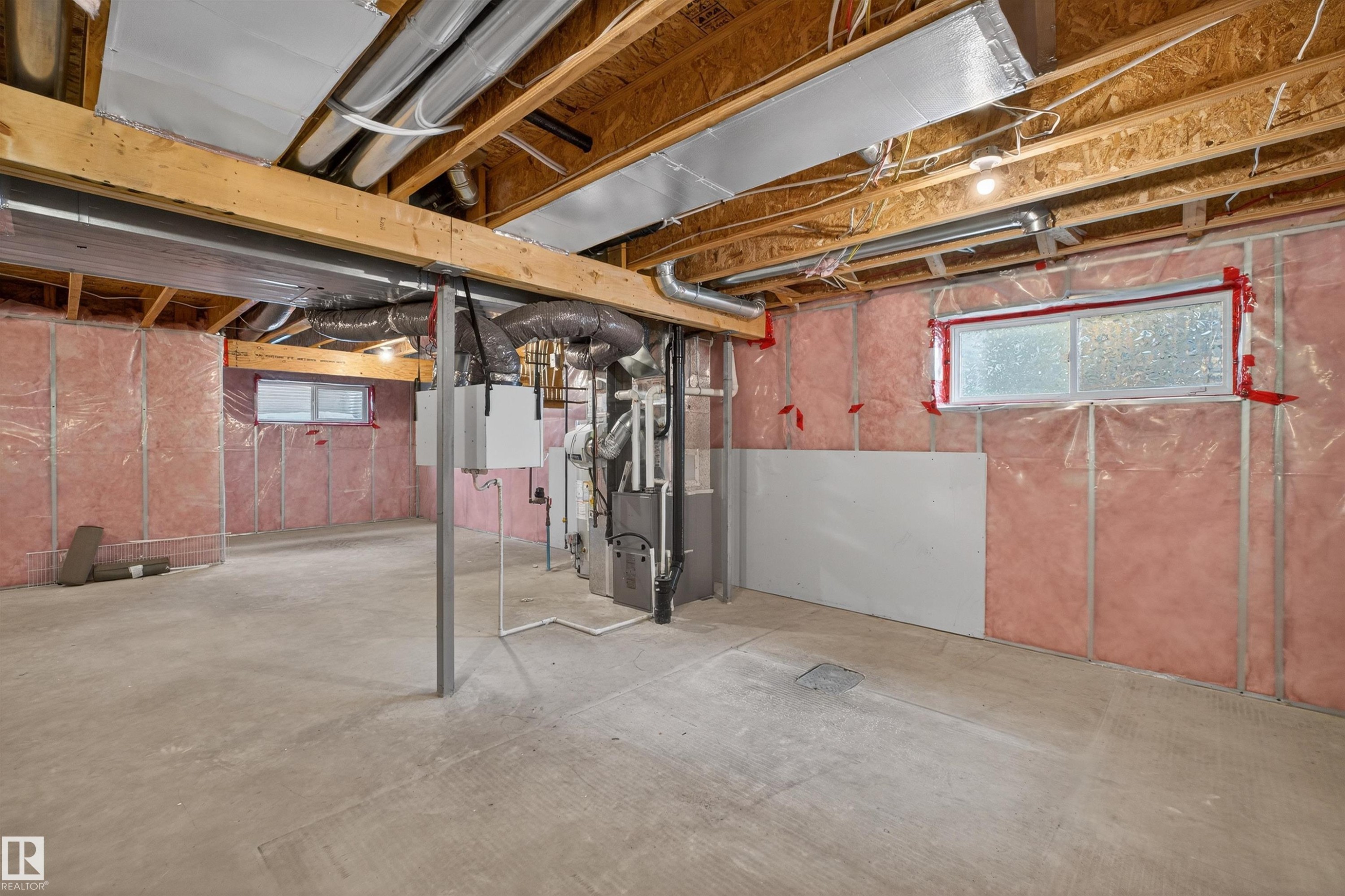 Unfinished basement featuring exposed wood joists, pink insulation, and concrete flooring - 4723 Alwood Bend Sw, Edmonton, AB - Indoor Photo Showing Basement