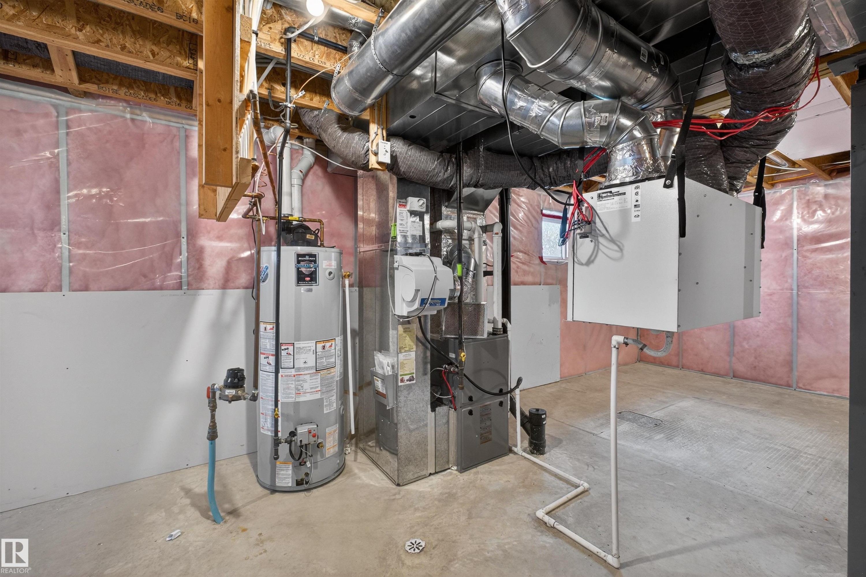 Unfinished basement featuring exposed wood framing, ceiling-mounted ductwork, a water heater, and a furnace system - 4723 Alwood Bend Sw, Edmonton, AB - Indoor Photo Showing Basement
