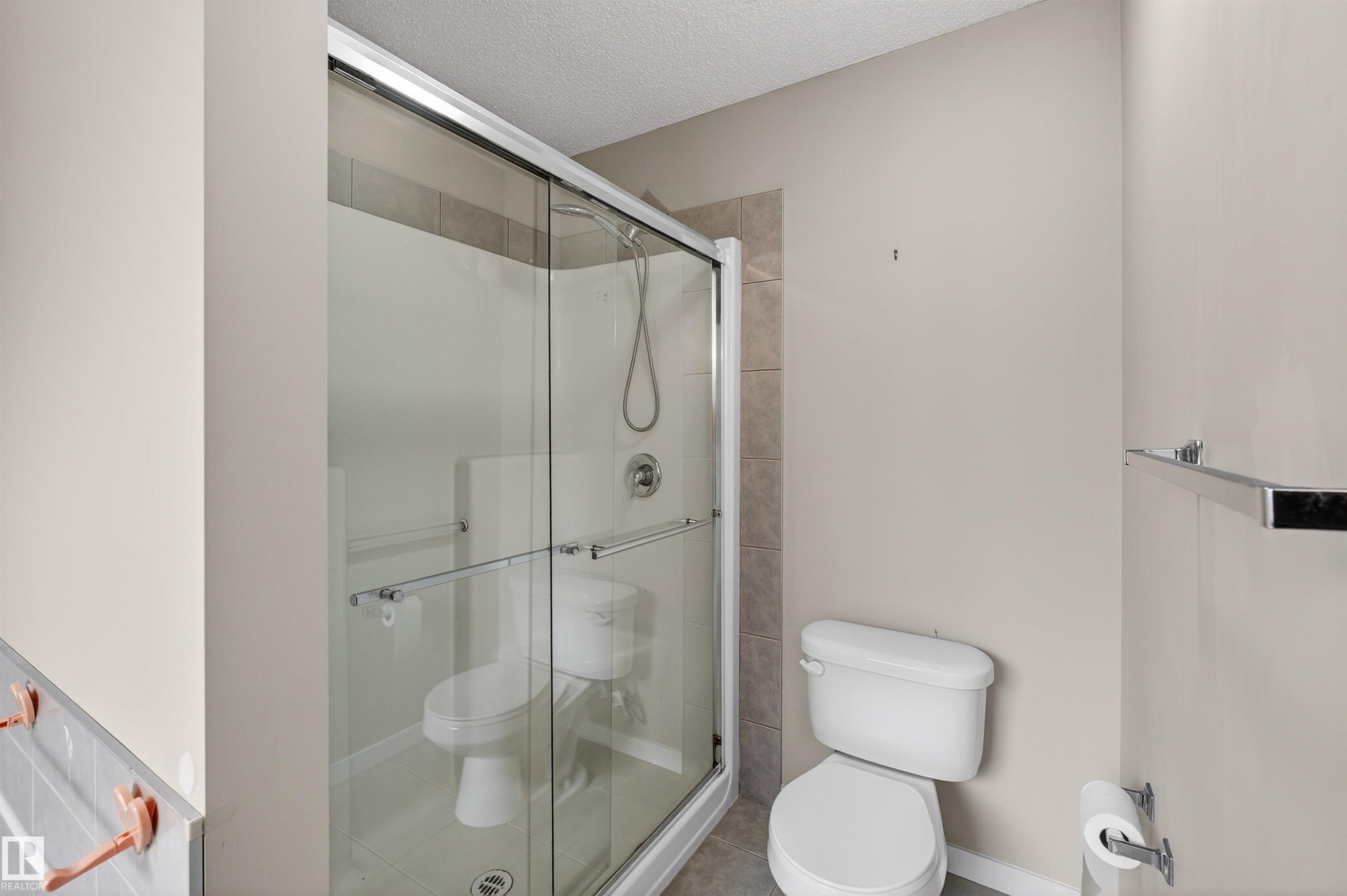 Glass-enclosed shower with a sliding door, chrome fixtures, and tiled surround - 4723 Alwood Bend Sw, Edmonton, AB - Indoor Photo Showing Bathroom