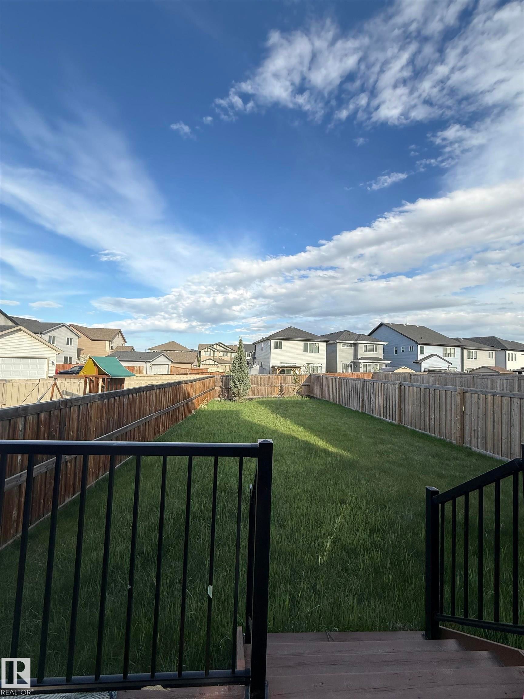 Expansive backyard featuring a manicured lawn, established privacy fencing, and a mature tree - 4723 Alwood Bend Sw, Edmonton, AB - Outdoor