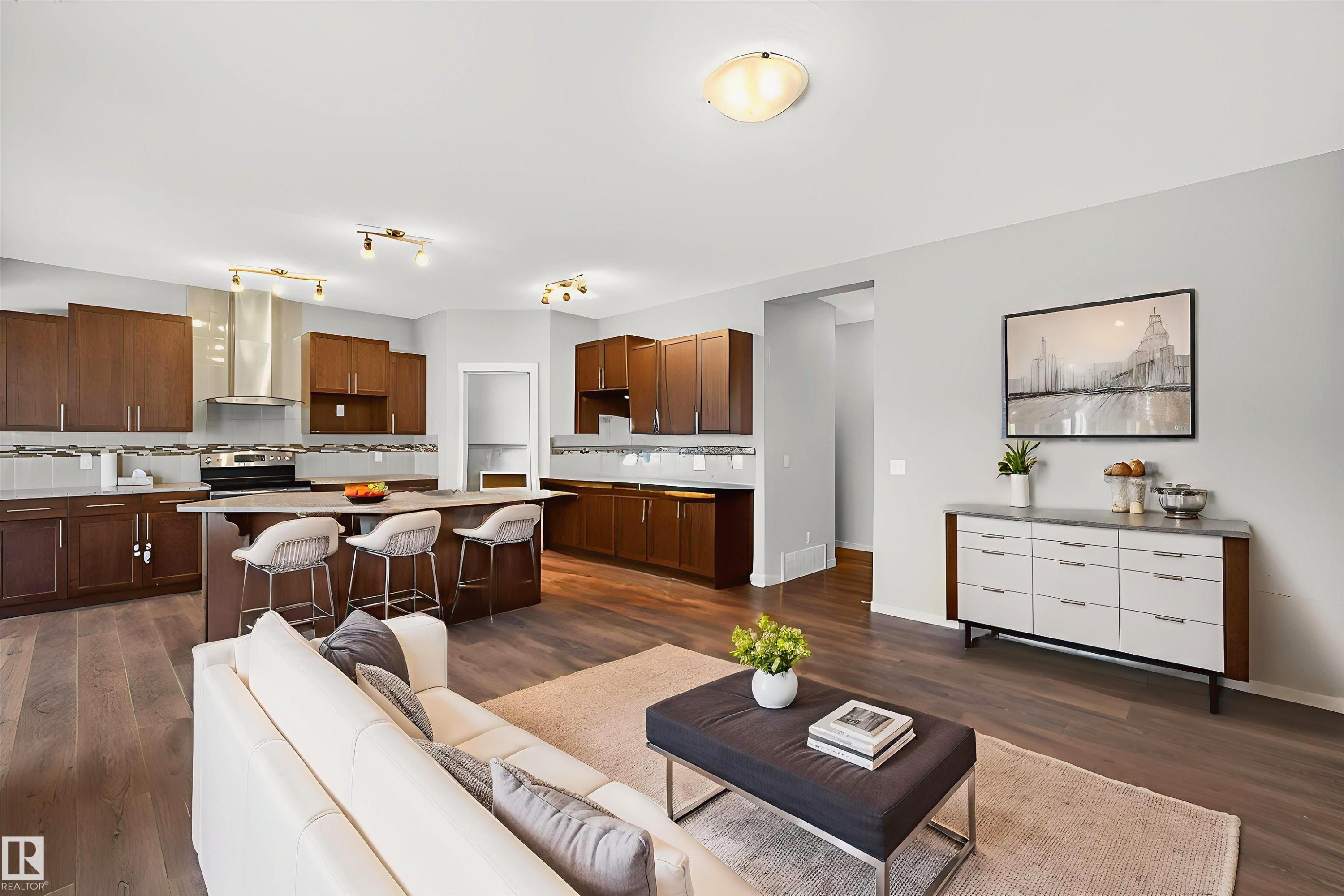 Open-concept kitchen and living area featuring wood-finish flooring, recessed lighting, and a neutral color palette - 4723 Alwood Bend Sw, Edmonton, AB - Indoor