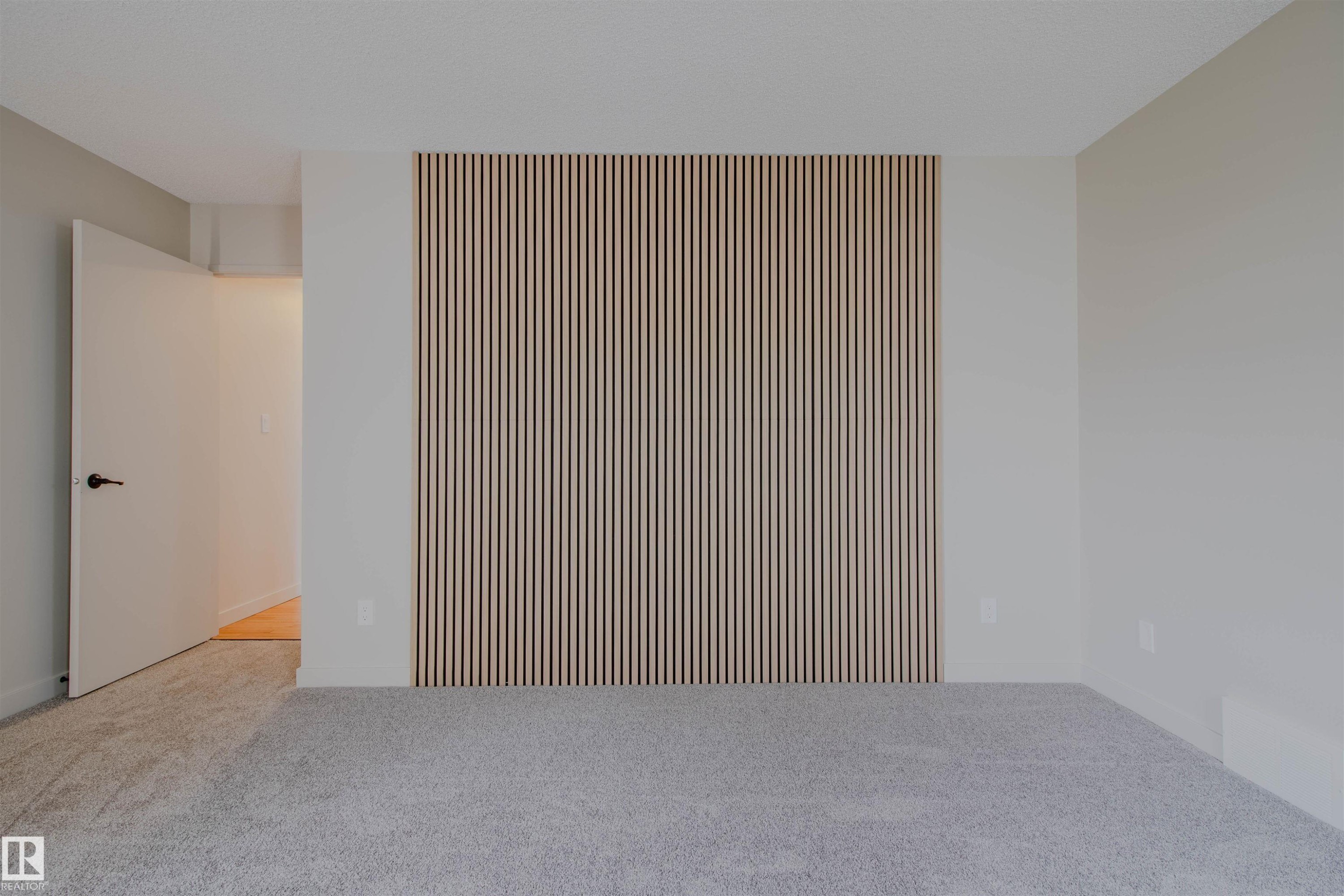Accent wall featuring vertical wood slat detailing - 5935 189 Street, Edmonton, AB - Indoor Photo Showing Other Room