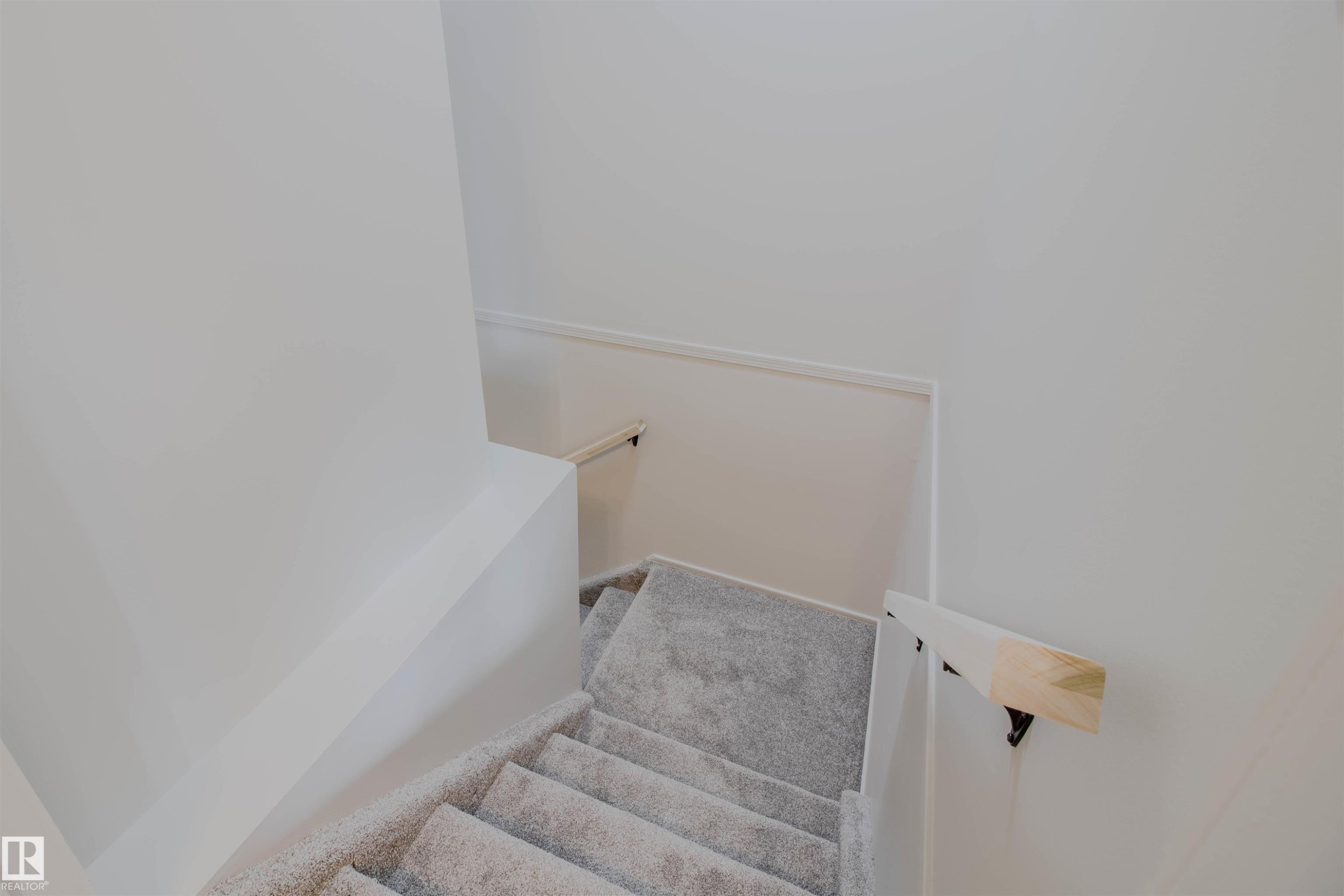 Carpeted stairs featuring a light gray hue and white baseboards - 5935 189 Street, Edmonton, AB - Indoor