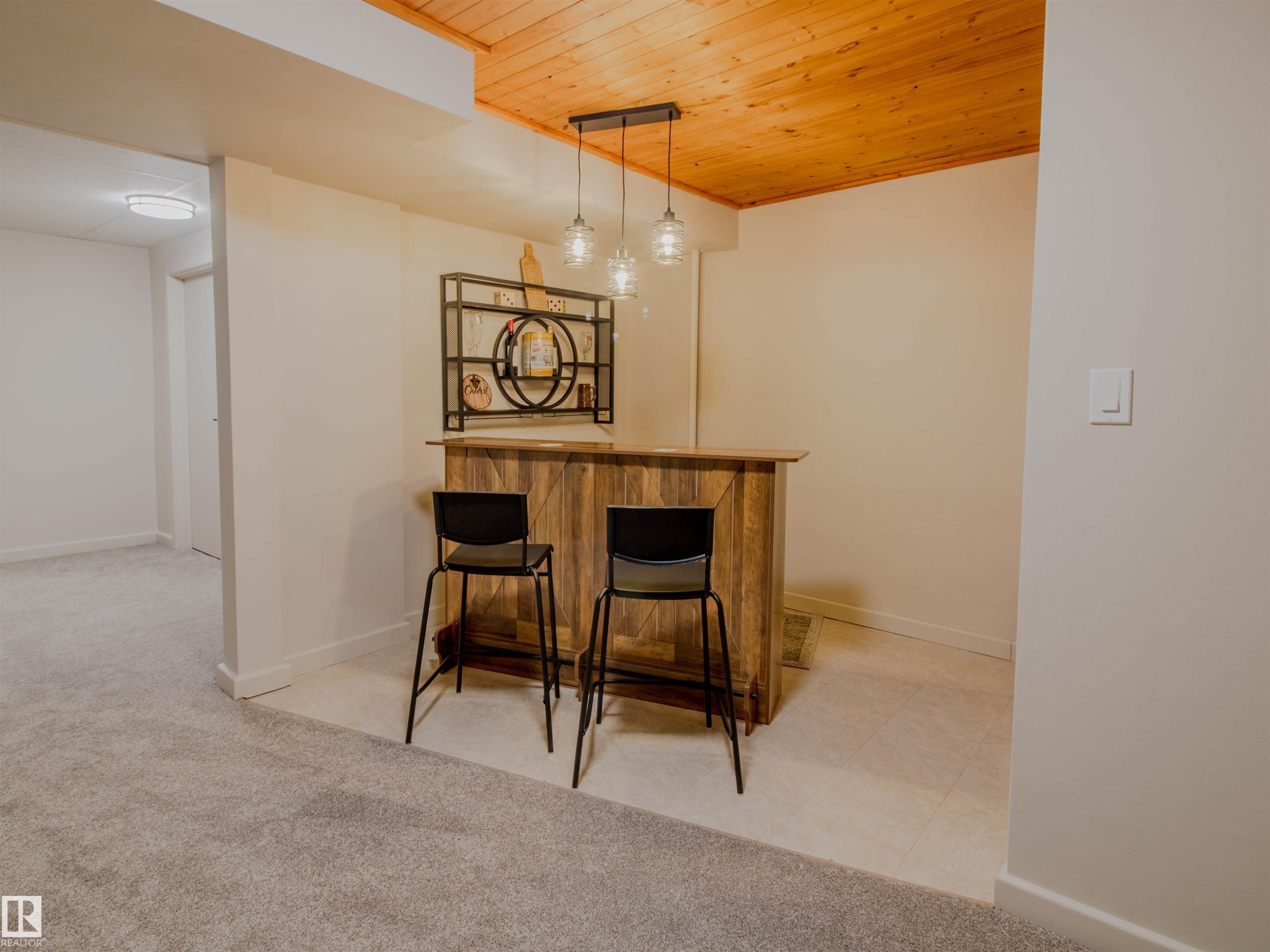 Custom-built bar featuring wood paneling, a wood countertop, and a decorative metal shelving unit - 5935 189 Street, Edmonton, AB - Indoor Photo Showing Other Room