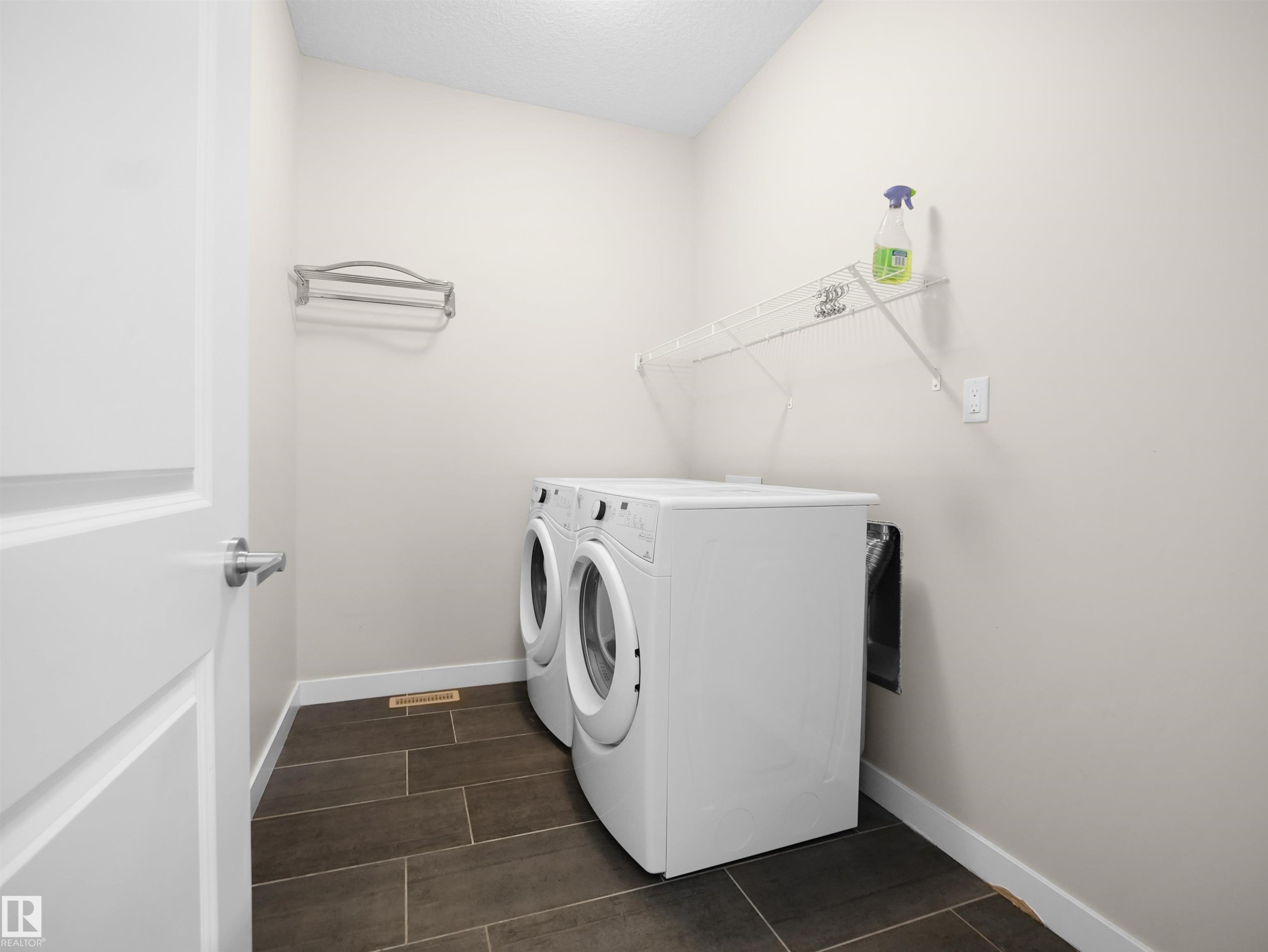 Dedicated laundry area featuring a front-loading washer and dryer set - 8921 217 Street Nw, Edmonton, AB - Indoor Photo Showing Laundry Room