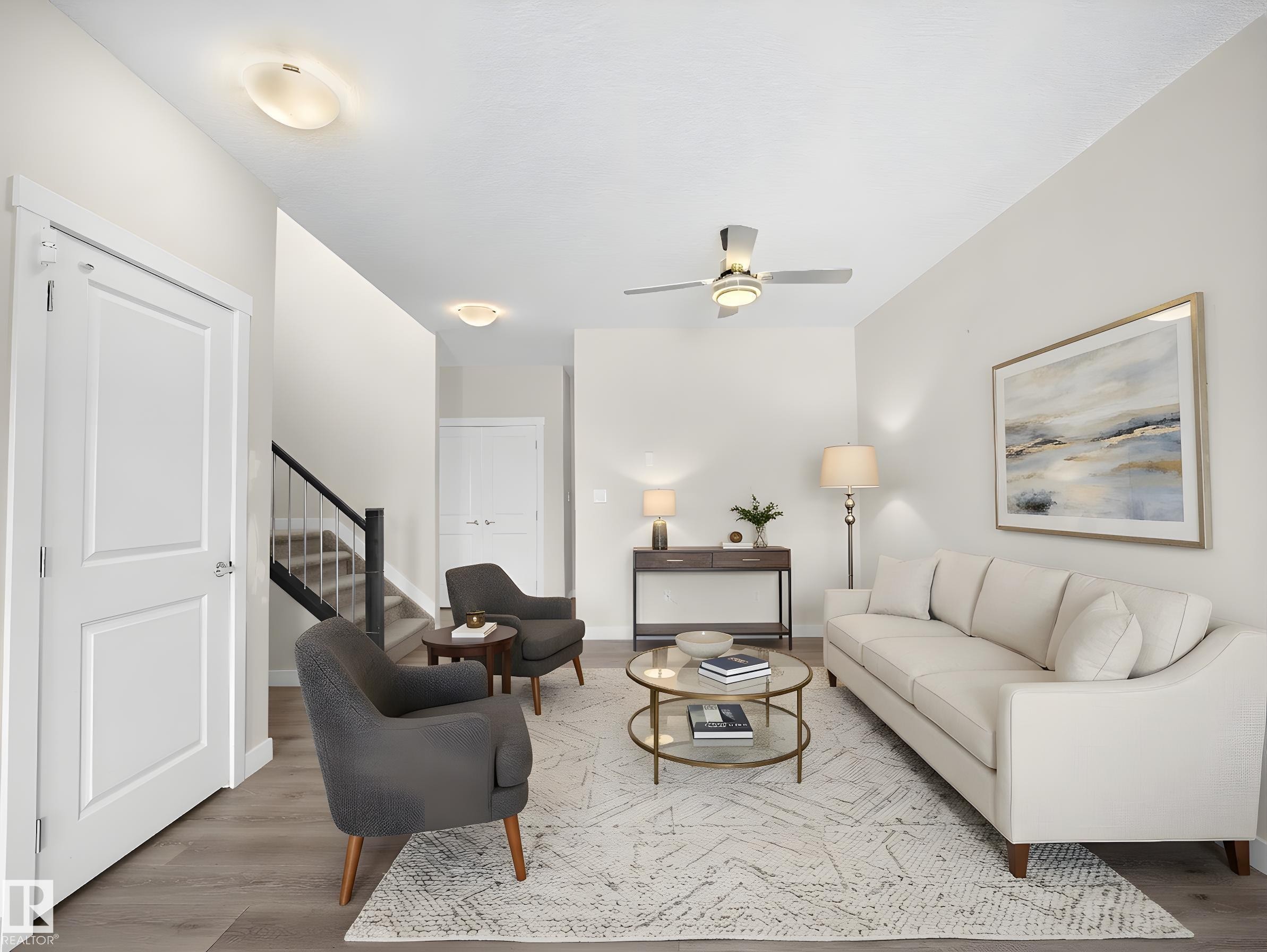 Spacious living area featuring wood-finish flooring, a ceiling fan with integrated lighting, and multiple flush-mount ceiling lights - 8921 217 Street Nw, Edmonton, AB - Indoor Photo Showing Living Room