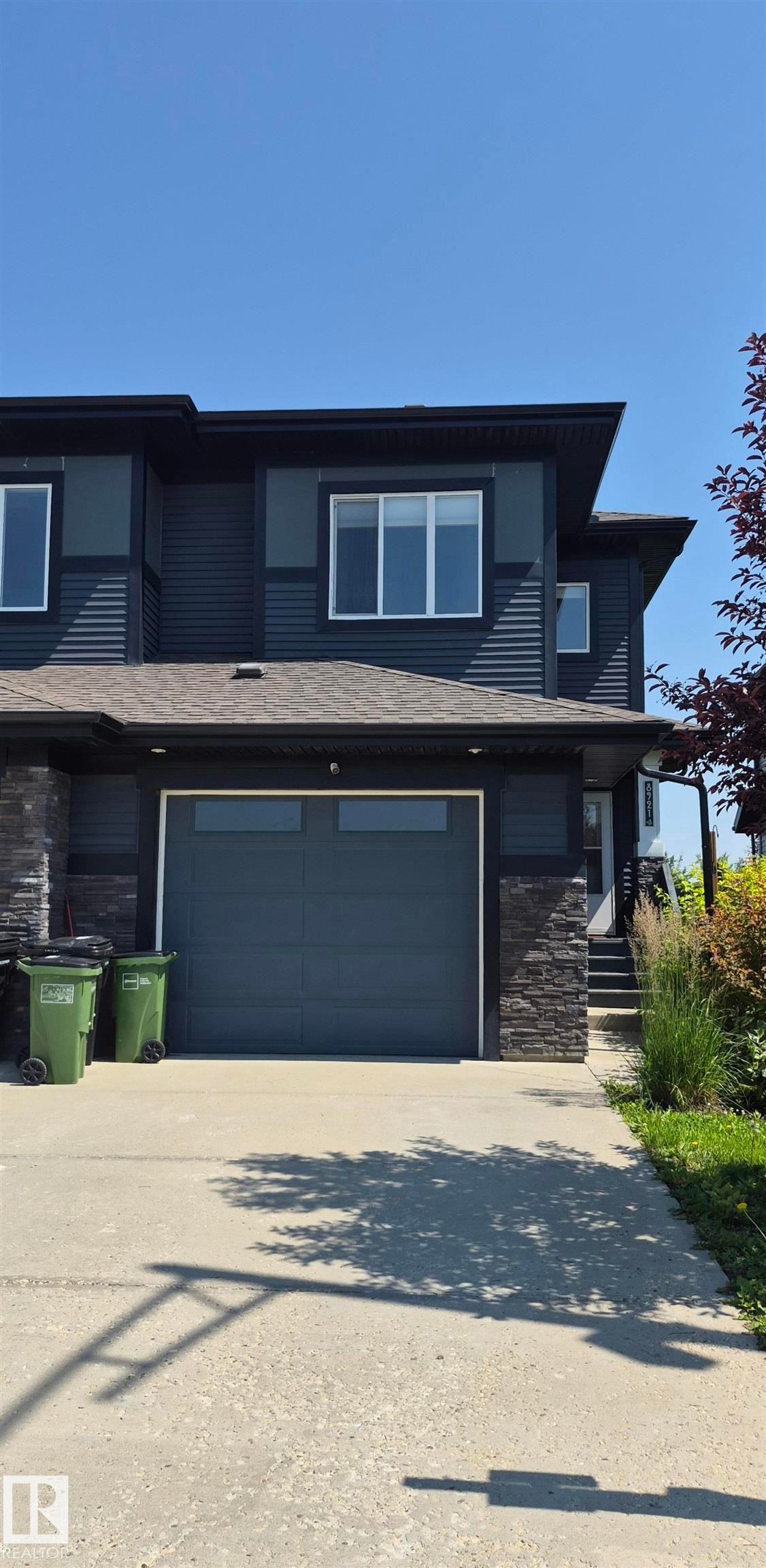 Contemporary dark-toned exterior featuring horizontal siding and stone veneer accents - 8921 217 Street Nw, Edmonton, AB - Outdoor