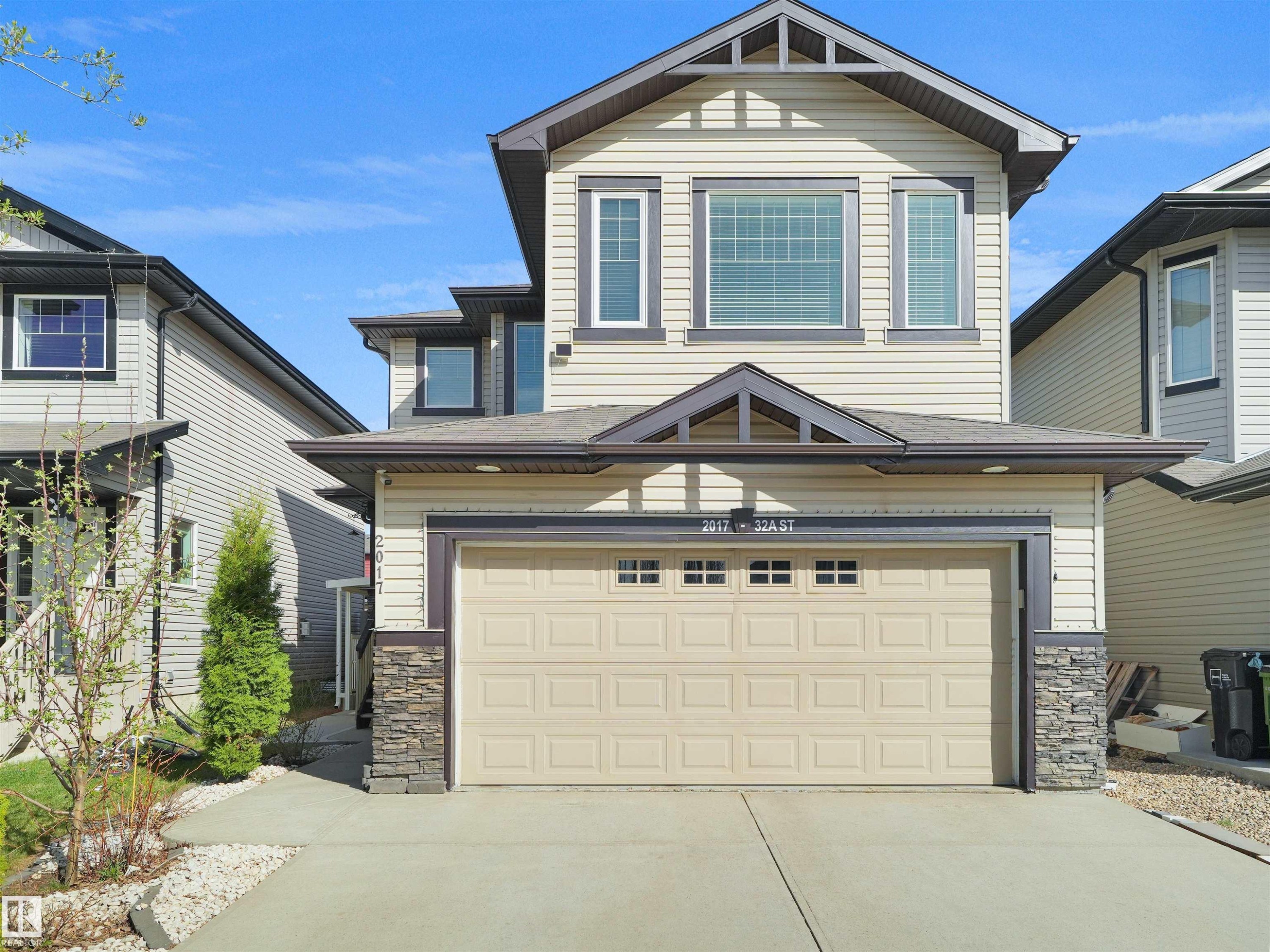 Contemporary two-story residence featuring light-toned siding and dark trim accents - 2017 32A Street, Edmonton, AB - Outdoor