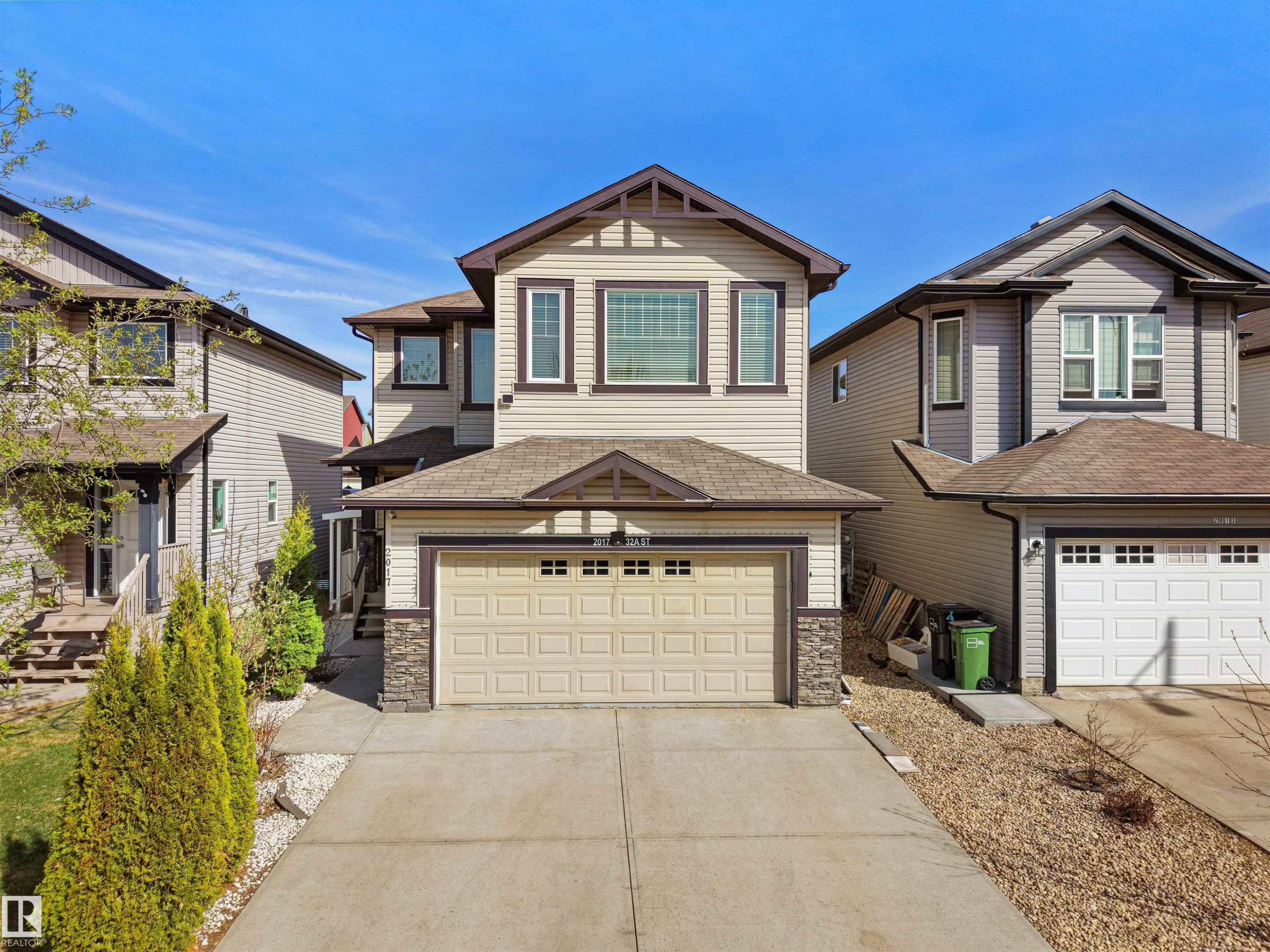 Two-story residence featuring light-colored siding and a two-car garage - 2017 32A Street, Edmonton, AB - Outdoor With Facade