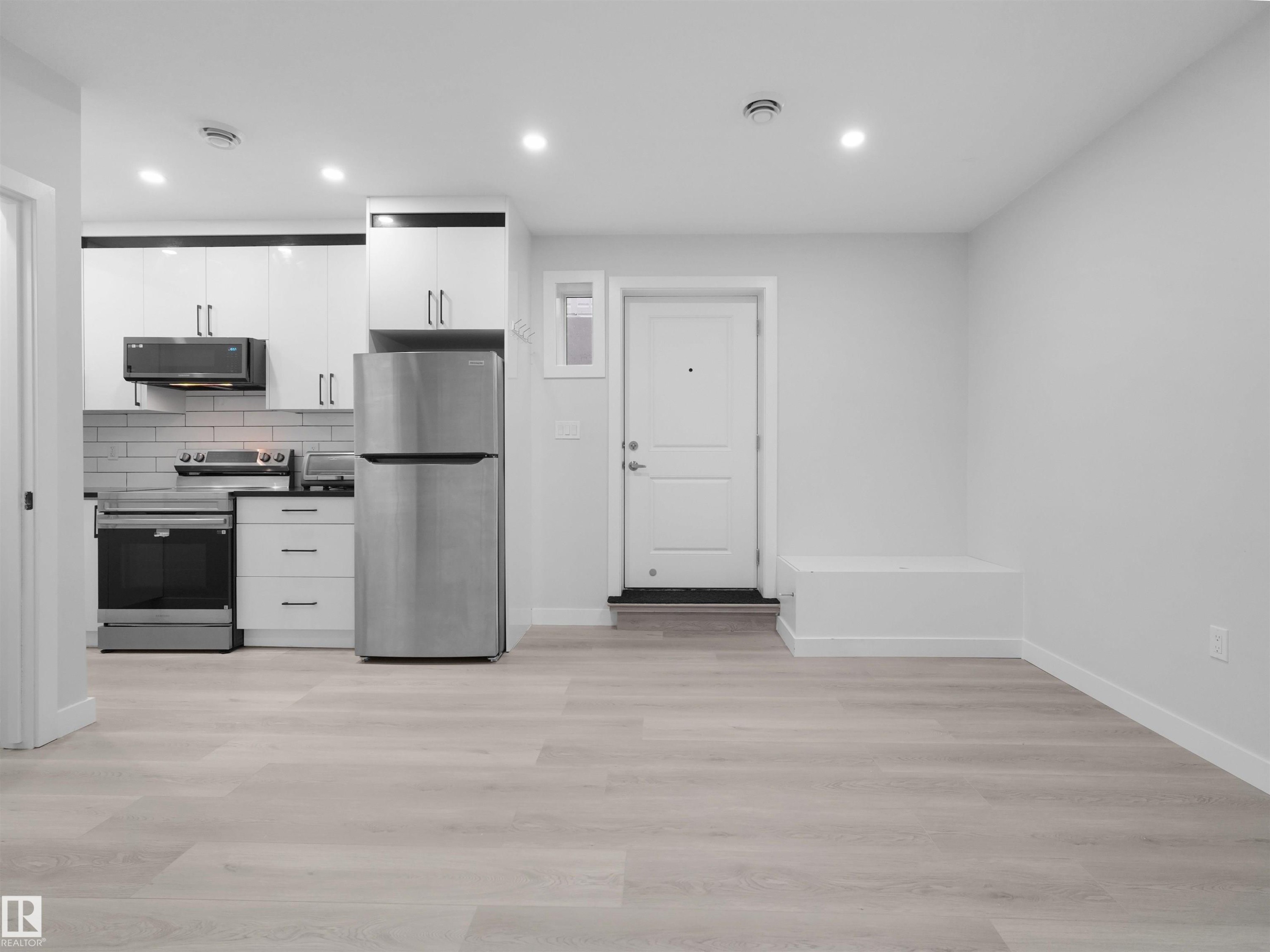Open-concept living area featuring light wood-finish flooring - 2017 32A Street, Edmonton, AB - Indoor Photo Showing Kitchen