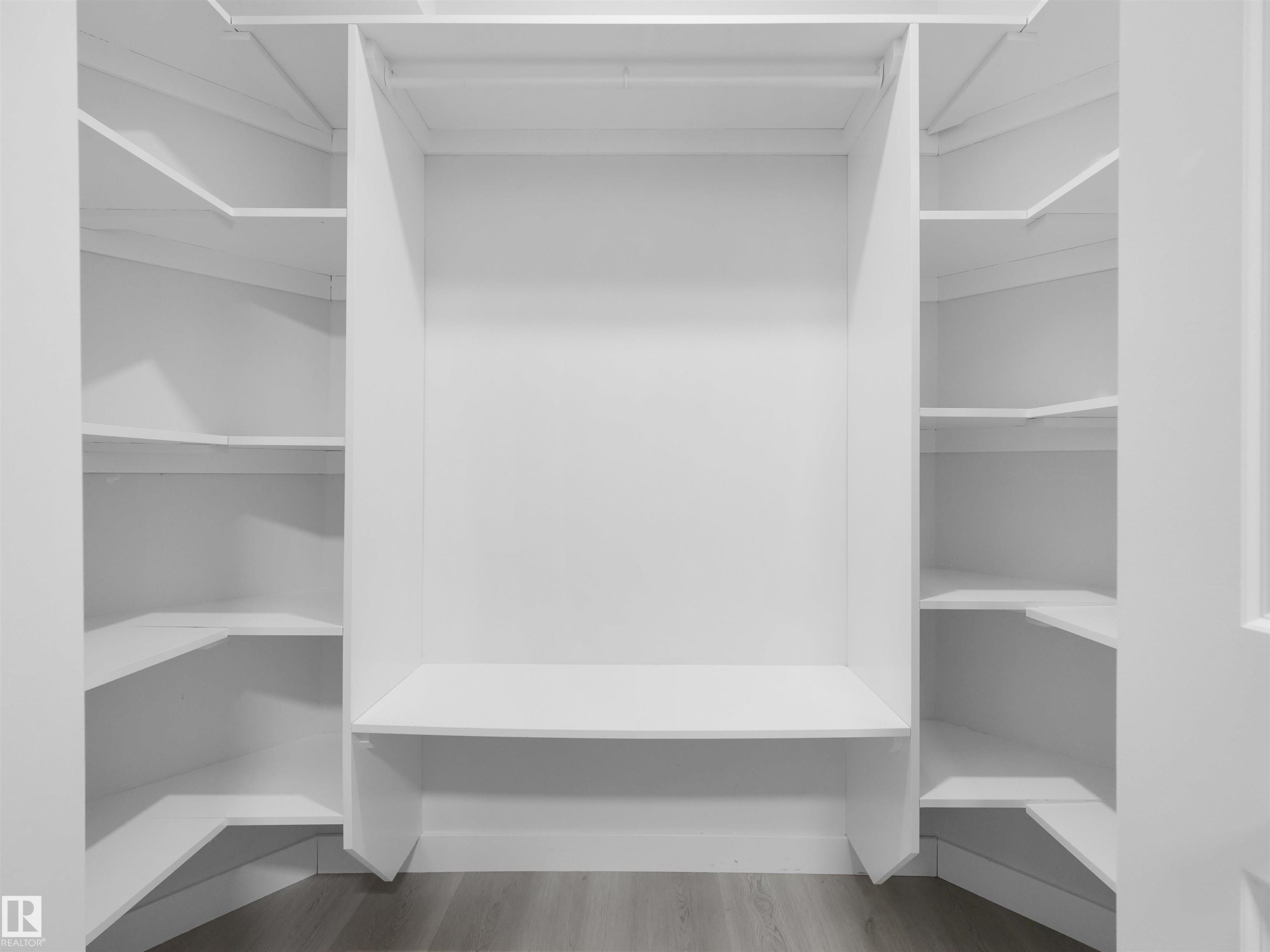 Custom closet system featuring white shelving and a built-in hanging rod - 2017 32A Street, Edmonton, AB - Indoor With Storage