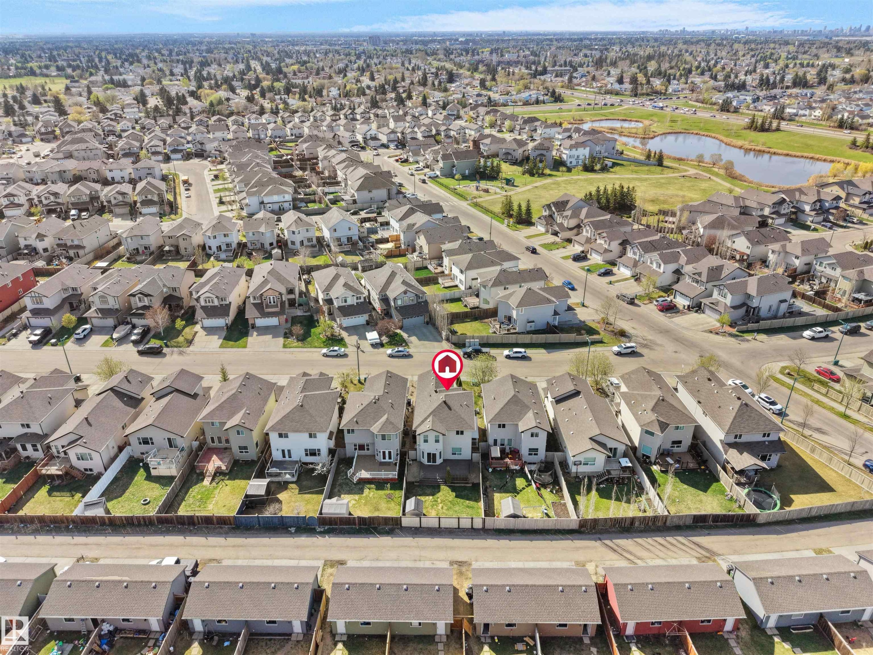 Aerial view of a residential neighborhood with detached homes, featuring a prominent pond and green space - 2017 32A Street, Edmonton, AB - Outdoor With View