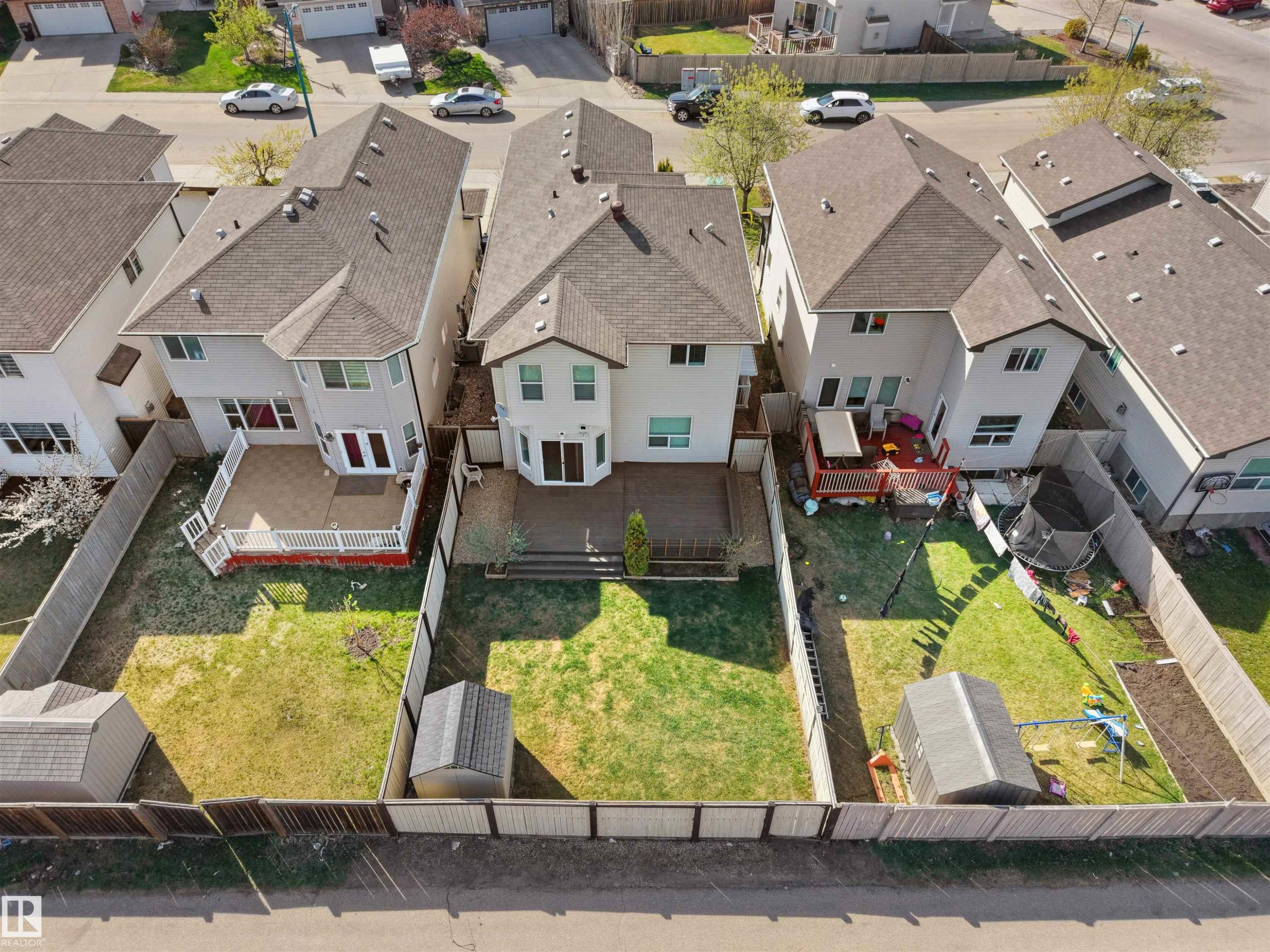 Two-story residential property featuring a large backyard with a wooden fence - 2017 32A Street, Edmonton, AB - Outdoor